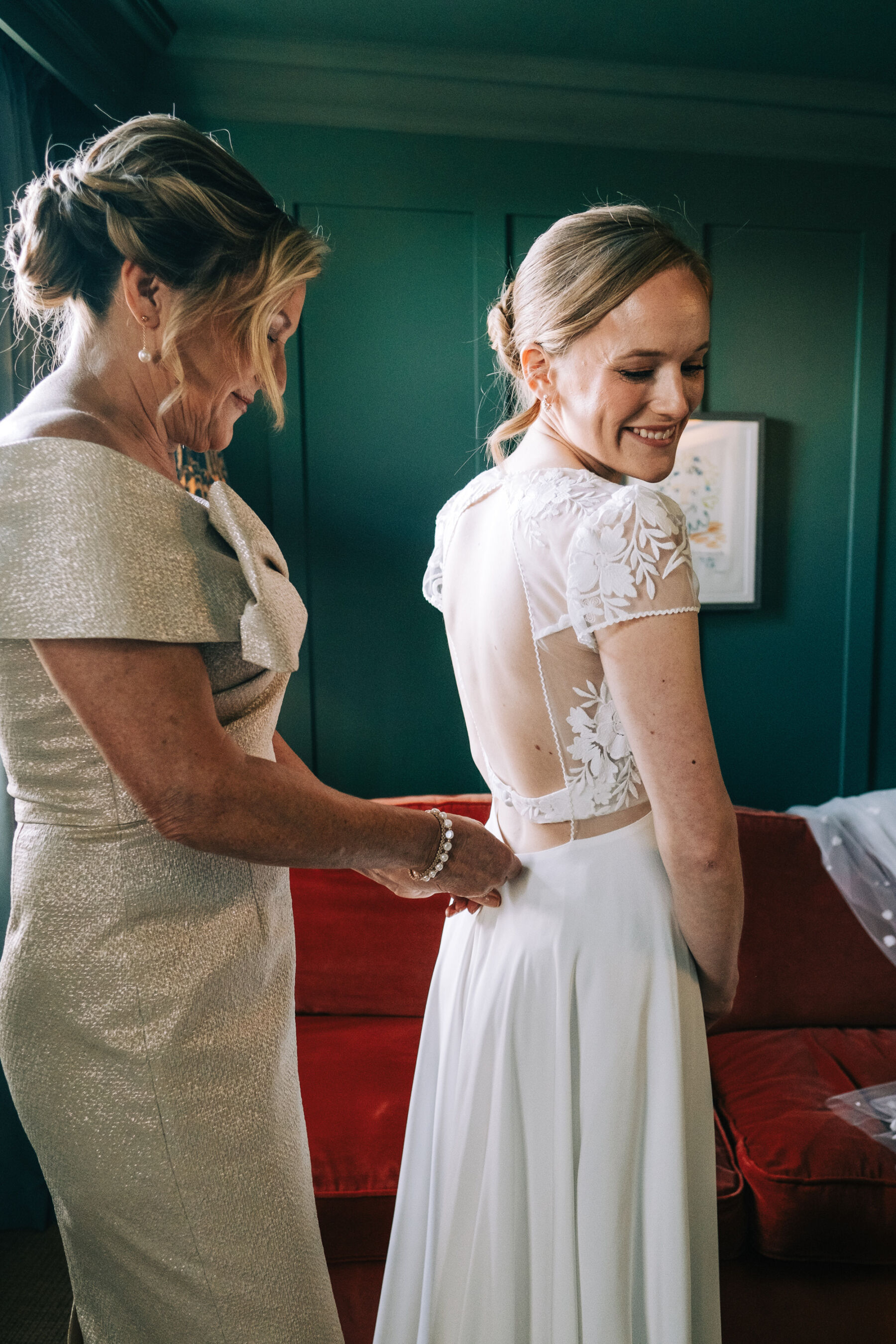Bride in a Rembo Styling wedding dress with mother of the bride doing her buttons up.