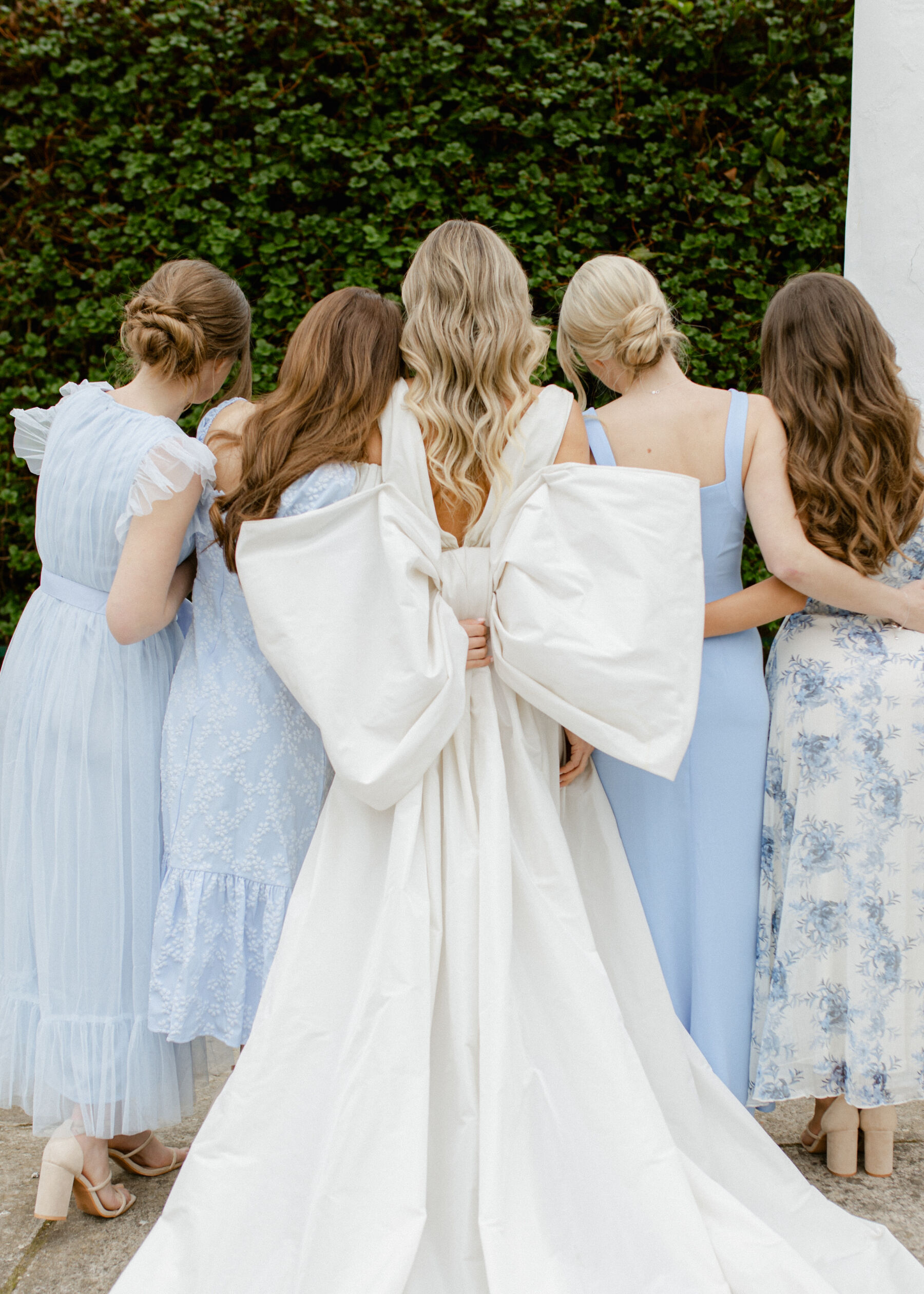 Halfpenny London wedding dress with large bow at the back. Bridesmaids wearing pale blue dresses. 