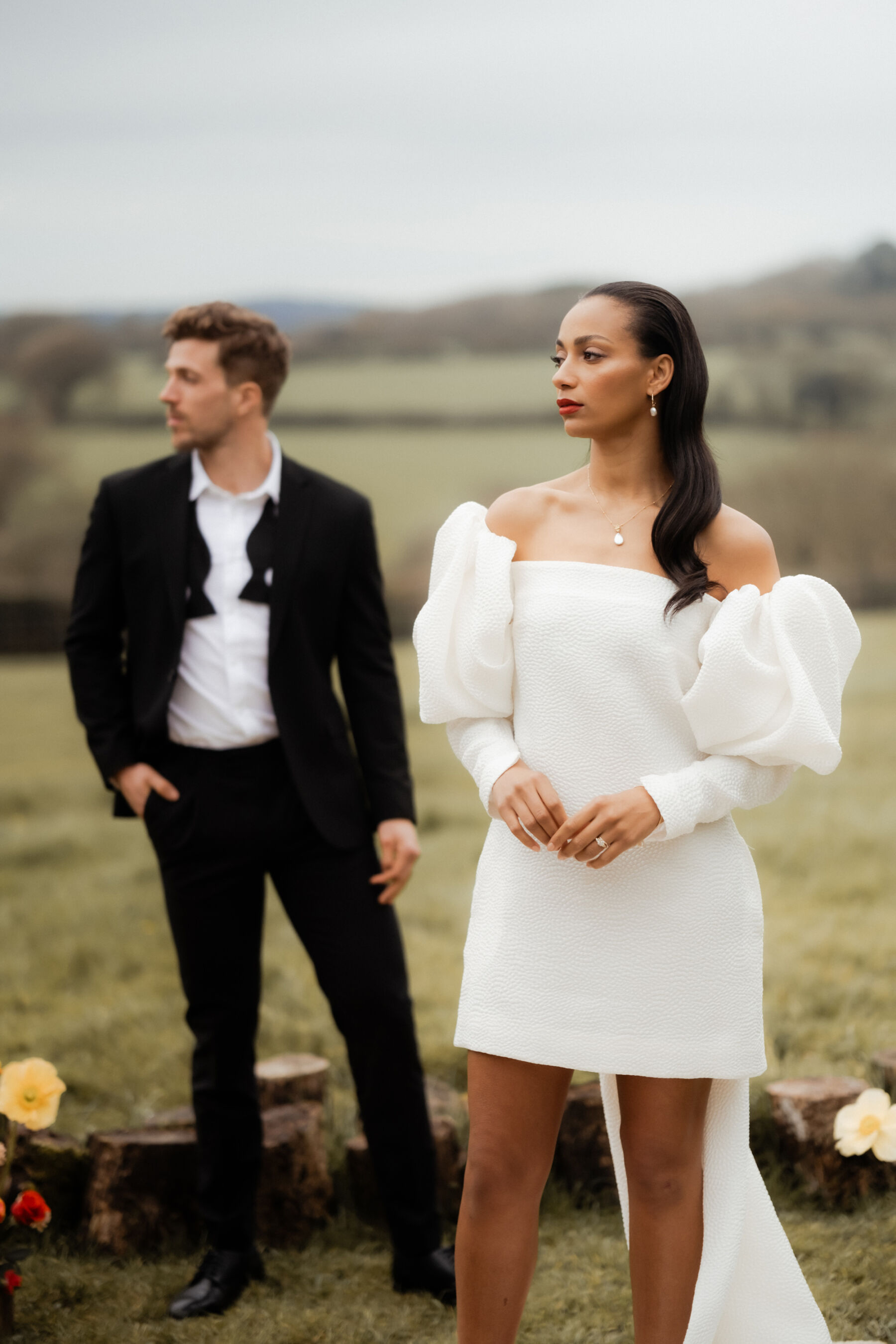 Bride wearing a short Jesus Peiro wedding dress with a long train and puff sleeves, from Miss Bush bridal boutique.