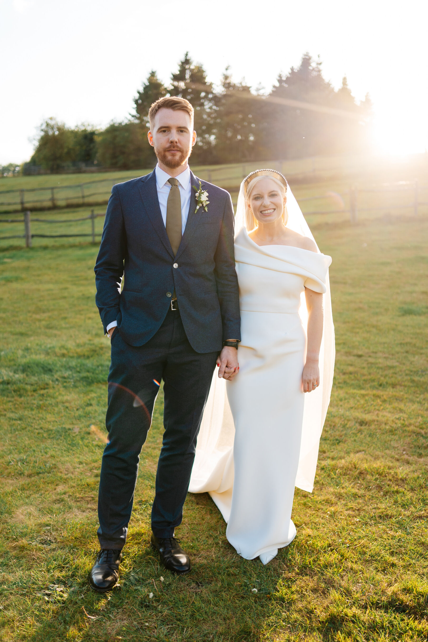 Bride wearing Toni Maticevski wedding dress & gold crown. Groom in a blue suit and green tie. Golden hour wedding photography by Marianne Chua Photography.