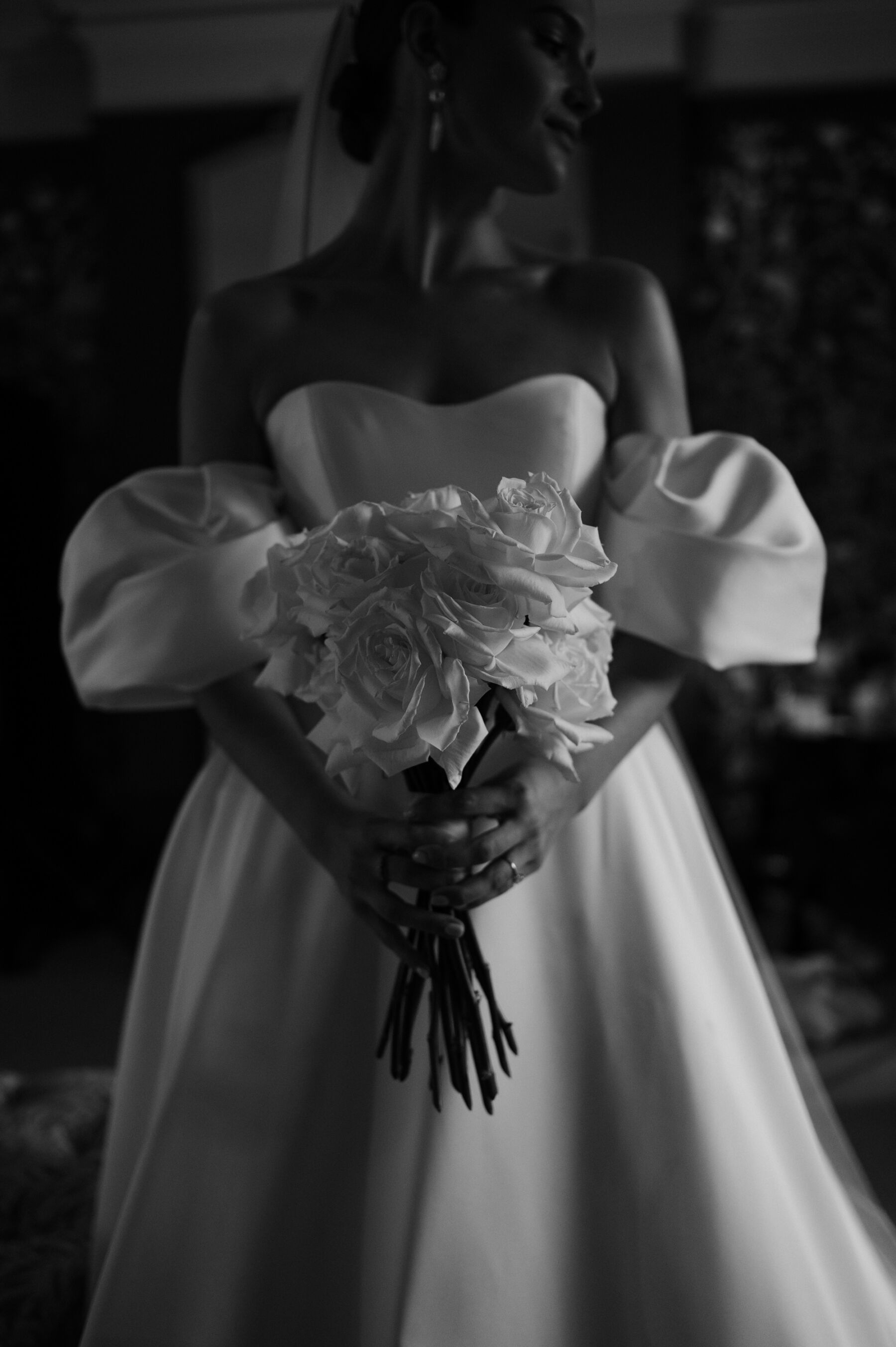 An Elegant Black Tie Wedding at Hampton Manor in Birmingham, with a Badgley Mischka Gown 27 Bride wearing a Badgley Mischka wedding dress with removable puff sleeves. She carries a white wedding bouquet. Taylor Hughes Photography.