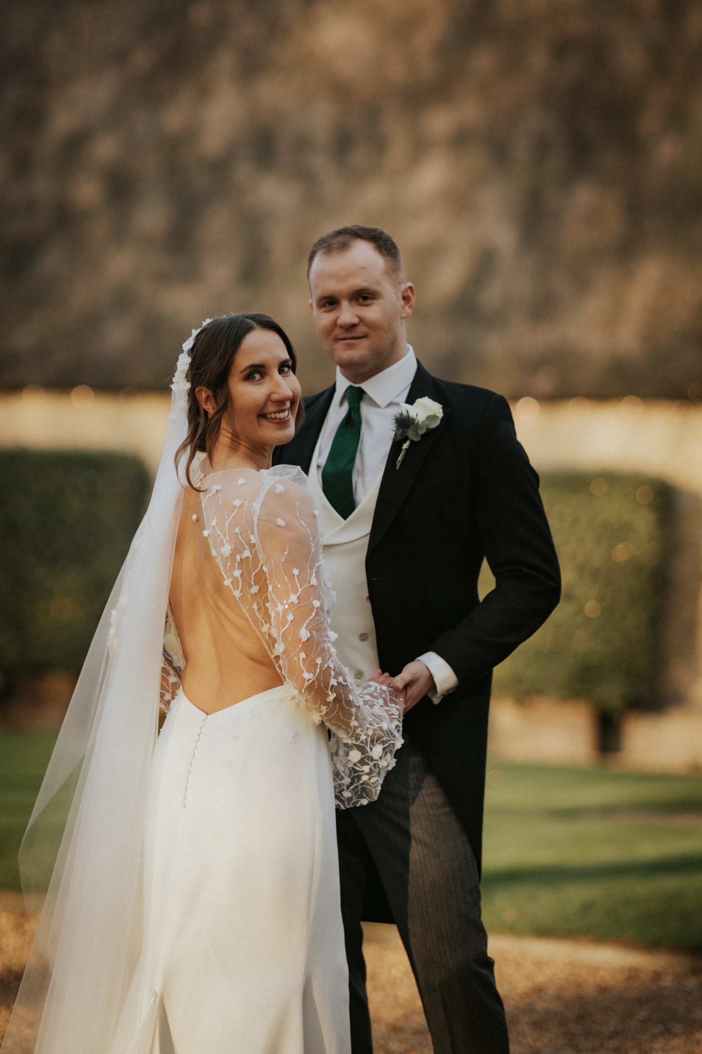 Bride in a backless Rime Arodaky wedding dress. Groom in traditional tails. Tythe Barn wedding venue, Oxfordshire.
