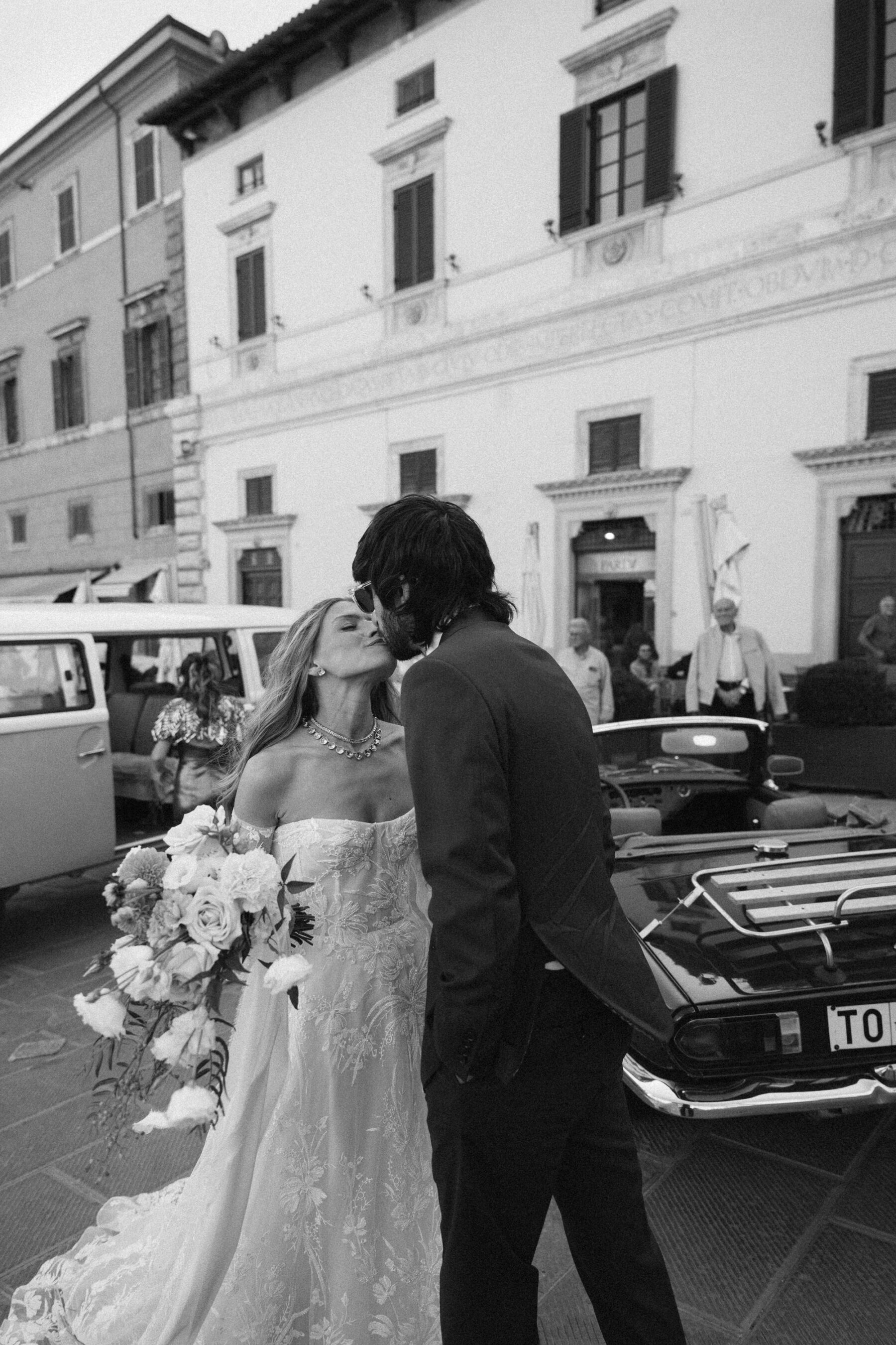 Mikaela in Alena Leena For Her Elegant Italian Wedding at Villa Fattoria di Vibio 26 Black and white photography of bride and groom kissing one another in Italian streets. Photography by Stefano Santucci.