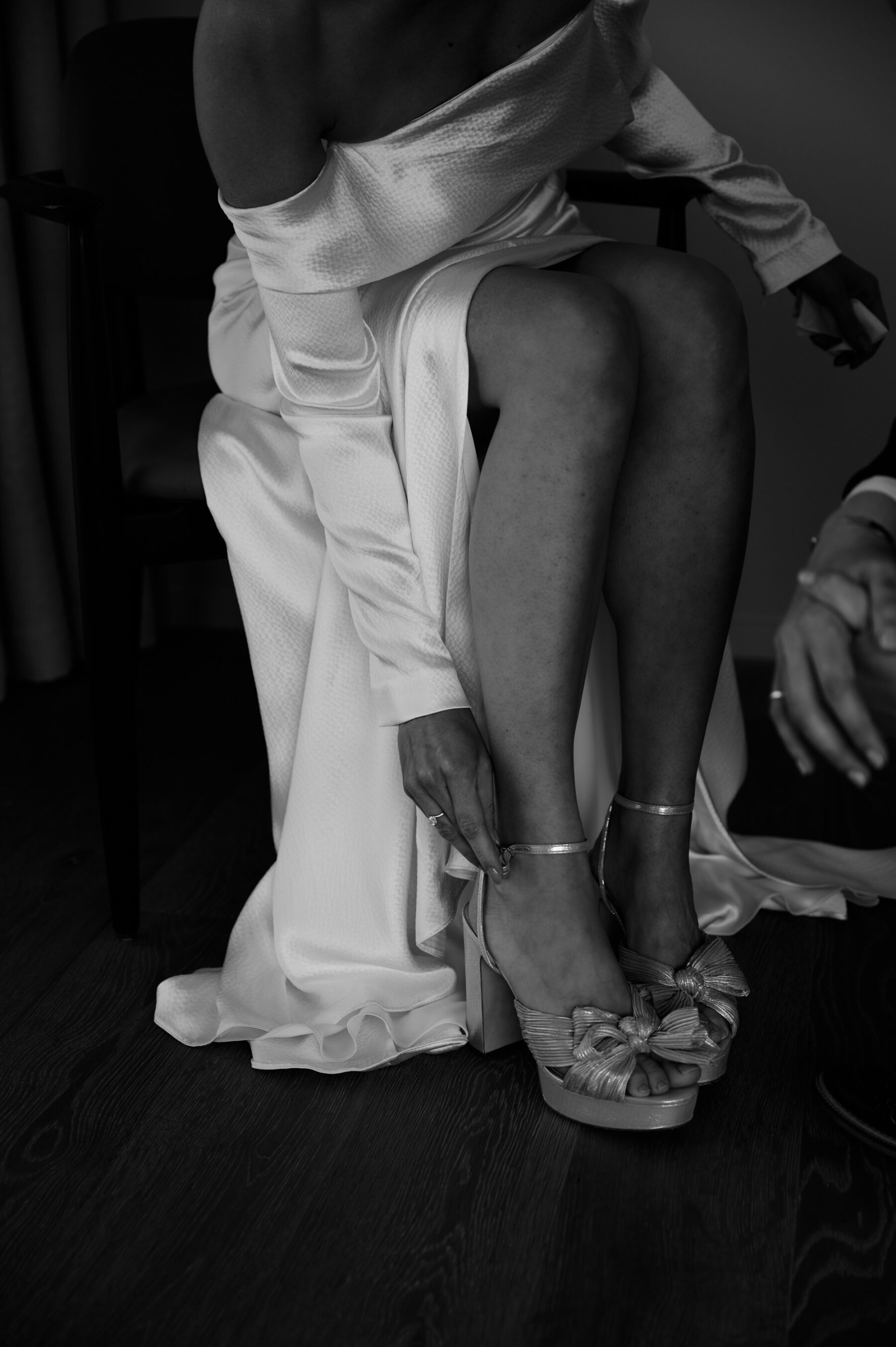 A Chic London Wedding: Soraya's Nikeen Asar Dress Captured by Taylor-Hughes Photography 7 Seated bride leaning over in her Nikeen Asar dress to buckle her Loeffler Randall Natalia shoes. Taylor-Hughes Photography.