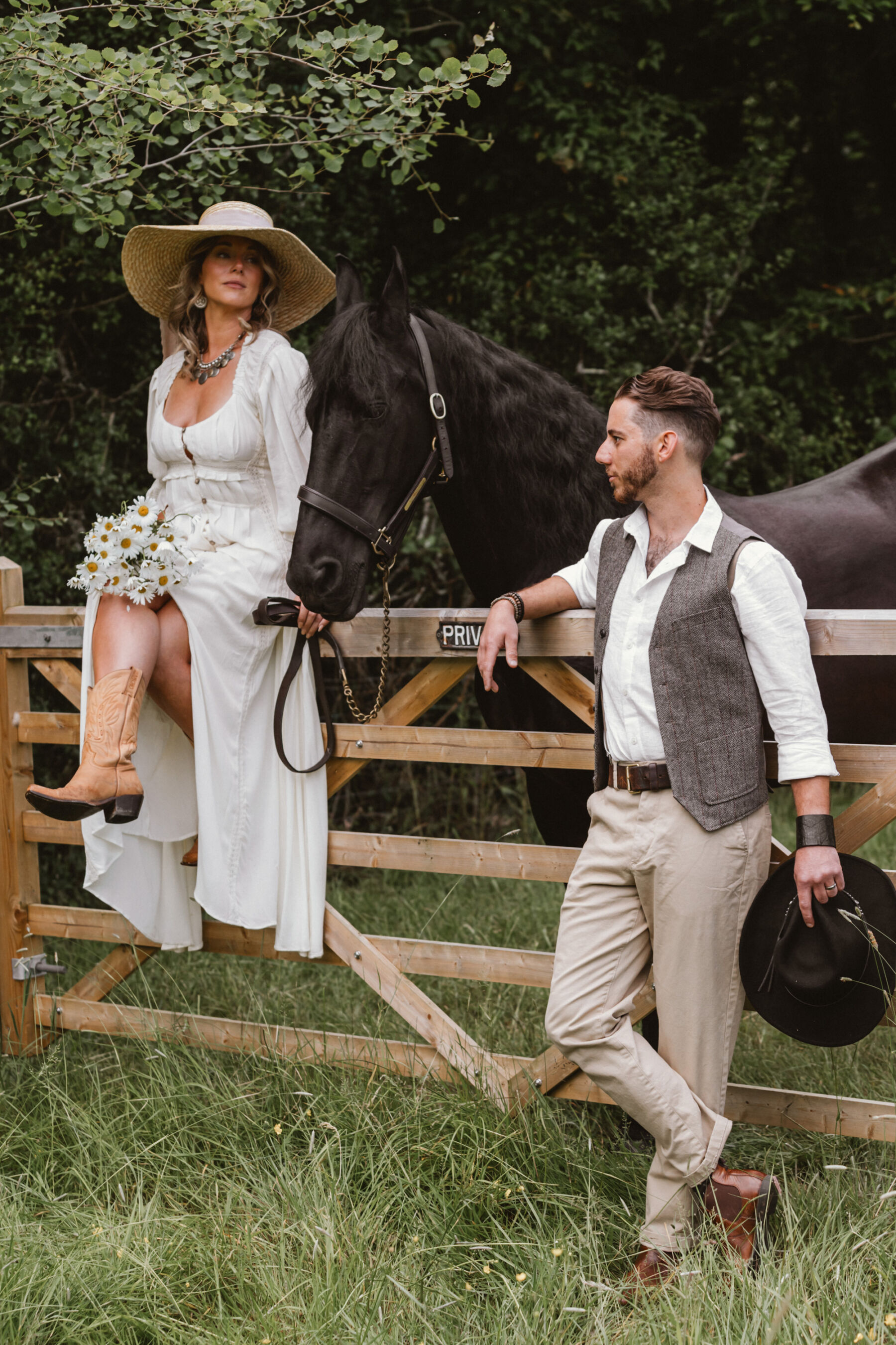 Wickerwood Farm, an Eco Friendly, Glamping Wedding Venue in East Sussex 13 Bride in a straw hat and sitting on a fence holding the reigns of a horse. Wickerwood Farm wedding venue, East Sussex.