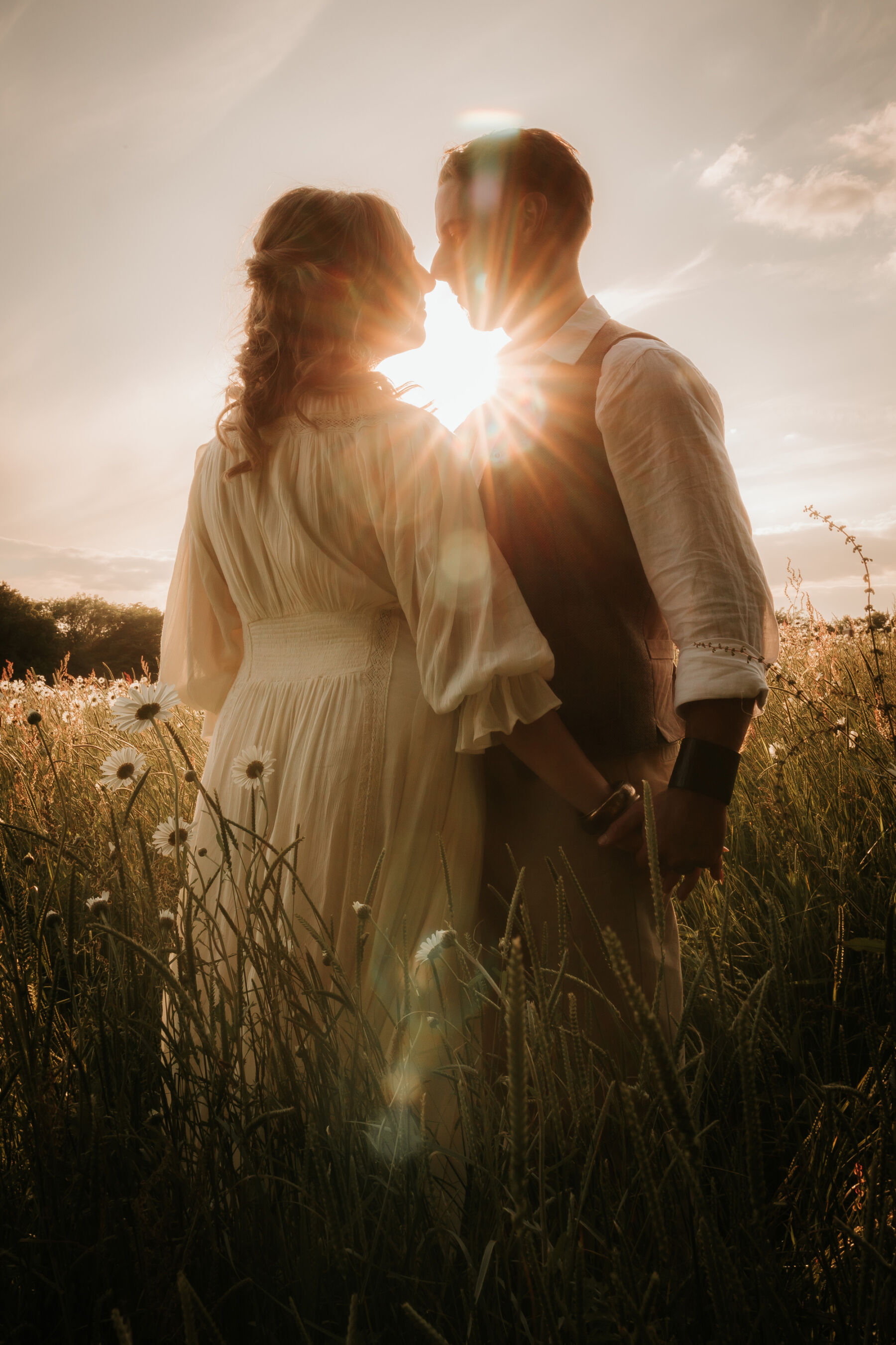 Wickerwood Farm, an Eco Friendly, Glamping Wedding Venue in East Sussex 34 Bride and groom embracing inside a wildflower meadow during golden hour at Wickerwood Farm wedding venue, East Sussex.