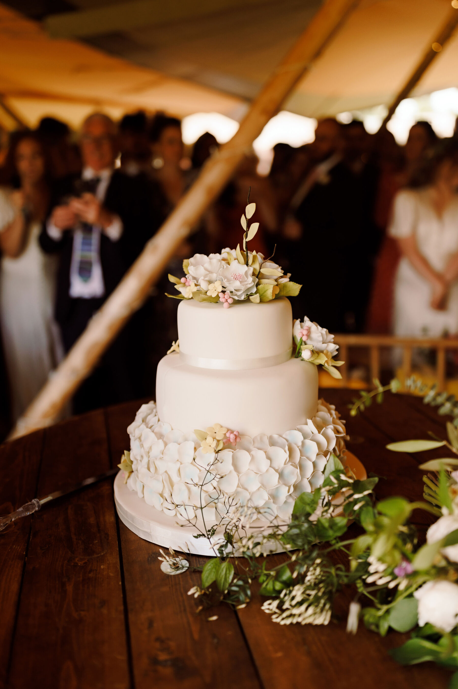 3 tier white wedding cake decorated with sugar petals and real flowers for a Midsummer Nights Dream inspired wedding.
