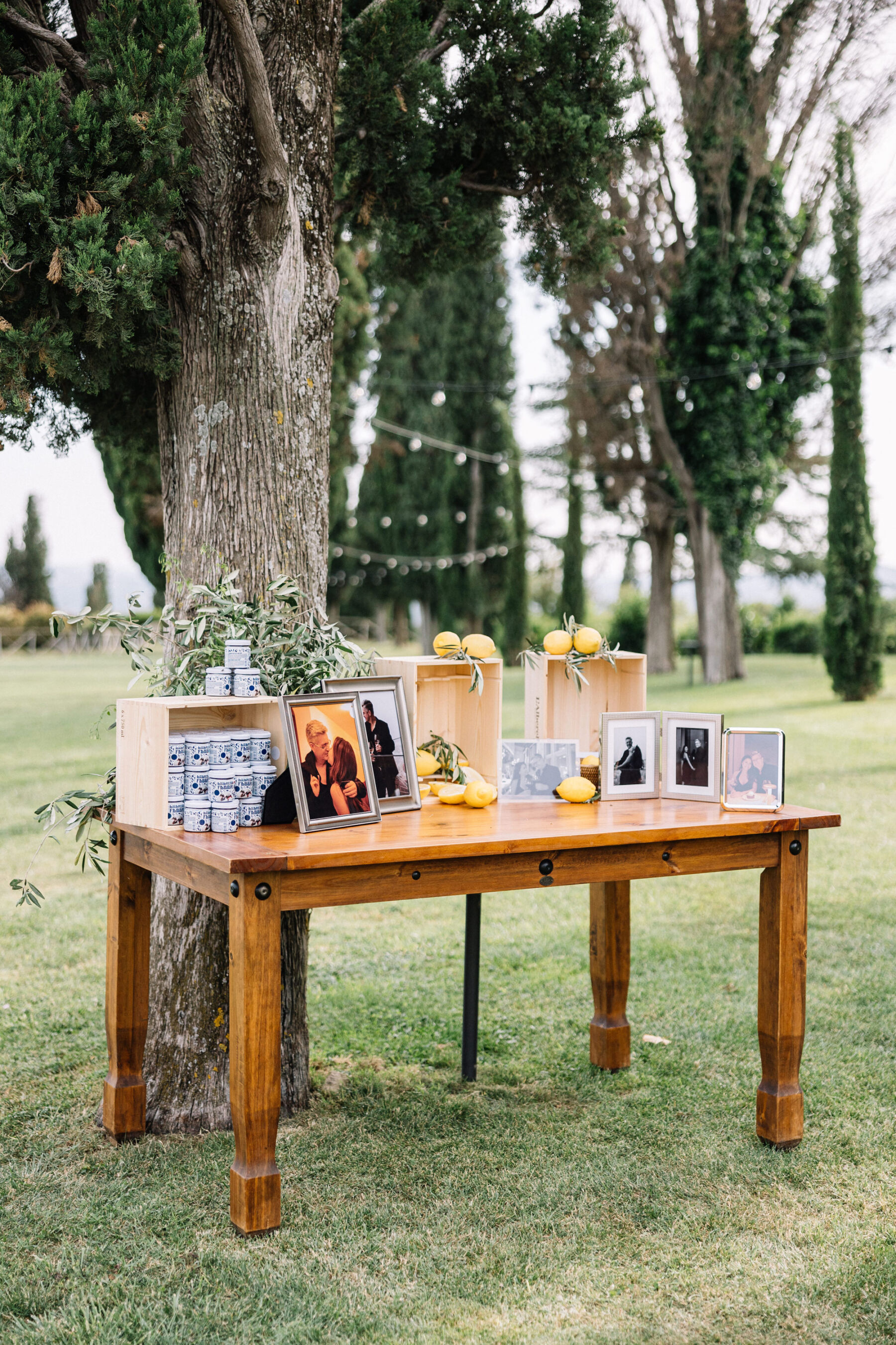 A Professional Wedding Planner's Wedding at Colle Massari in Tuscany, Italy 21 Table with framed photographs of the bride and groom and lemons - wedding decor for an outdoor wedding in Tuscany, Italy.