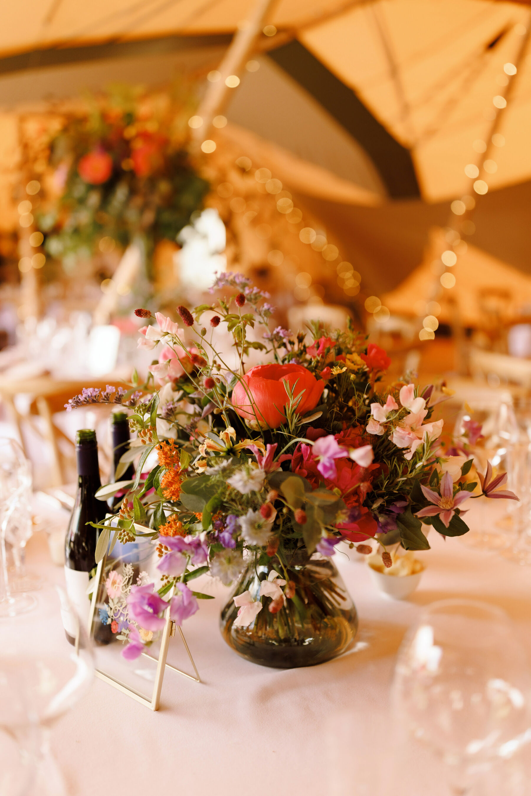 Colourful summer wedding table flowers for a Midsummer Nights Dream inspired wedding.