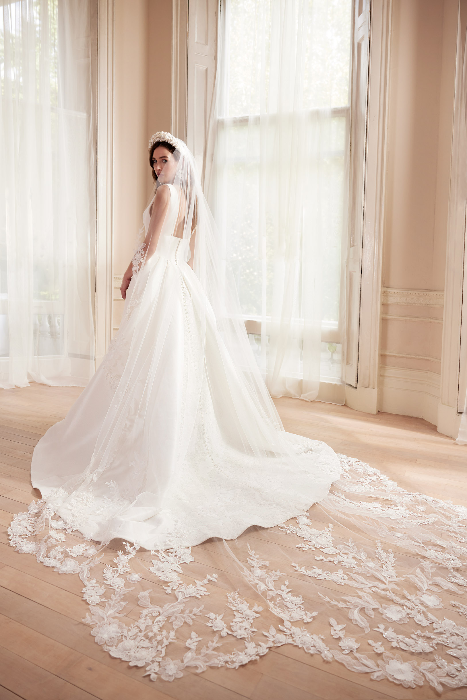 Elegant modern wedding dress with long lace veil by Josephine Scott.