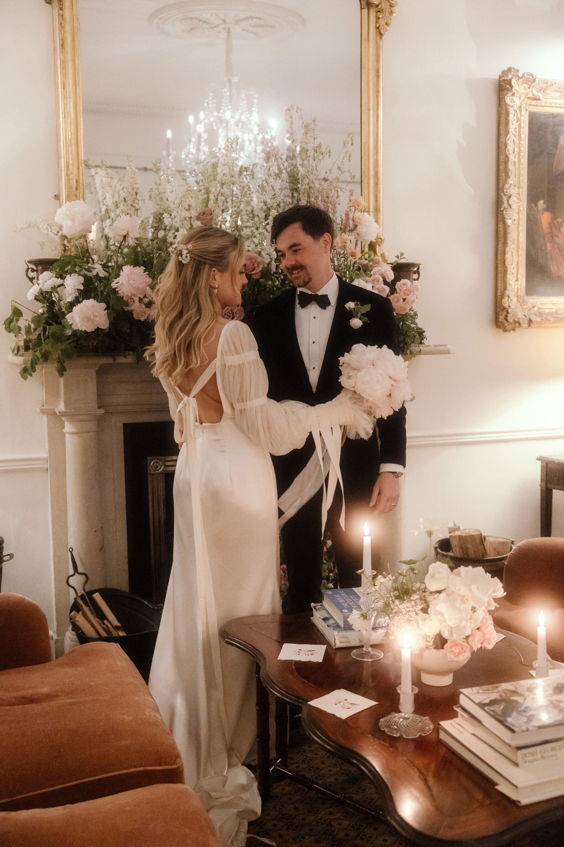Romantic Ballynahinch Castle Wedding: Ciara in Danielle Frankel 34 Bride wearing Danielle Frankel and holding a blousy, romantic wedding bouquet as she smiles back at her groom in black tie.