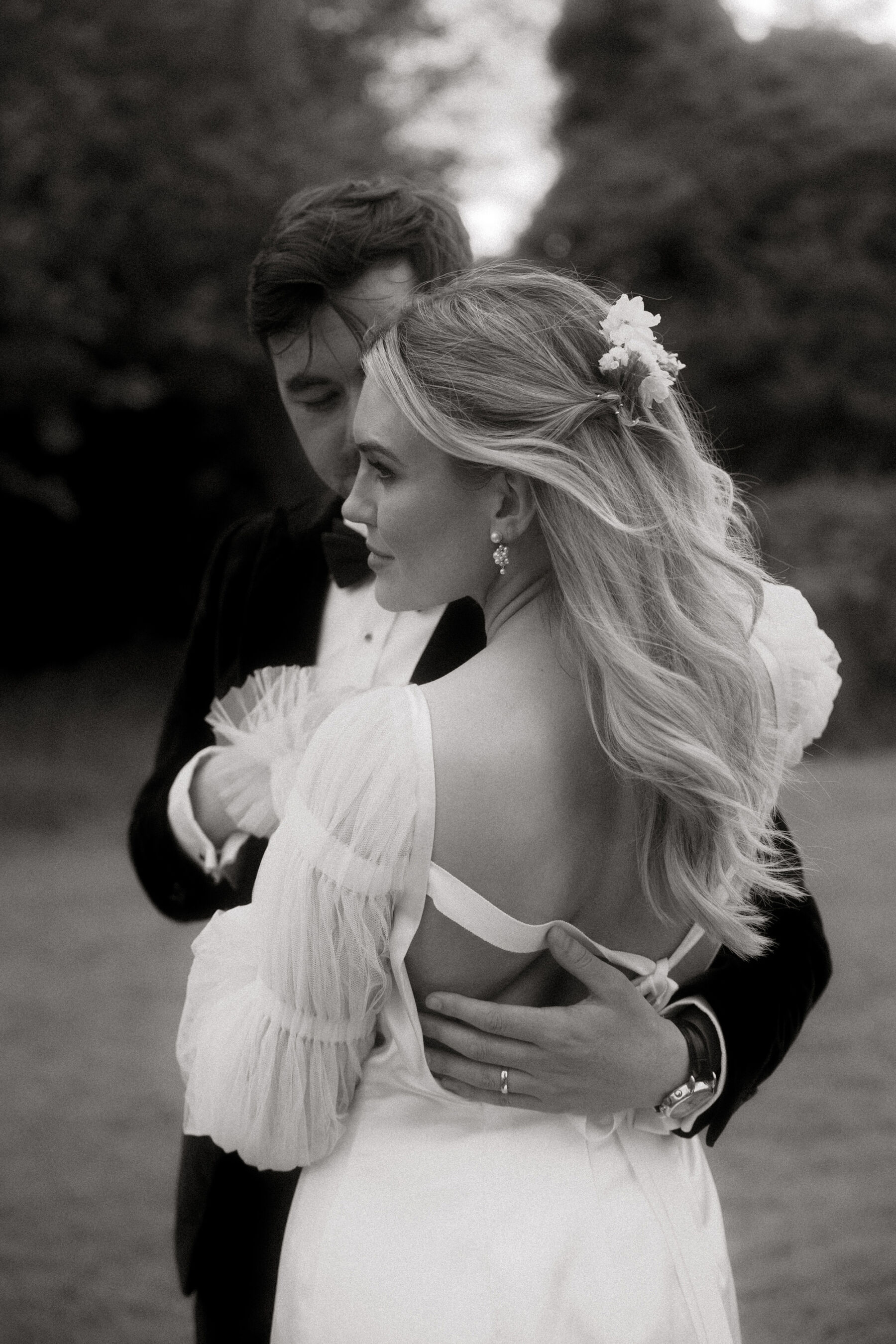 Romantic Ballynahinch Castle Wedding: Ciara in Danielle Frankel 29 Bride wearing a dress by Danielle Frankel whilst being hugged by her groom in black tie.
