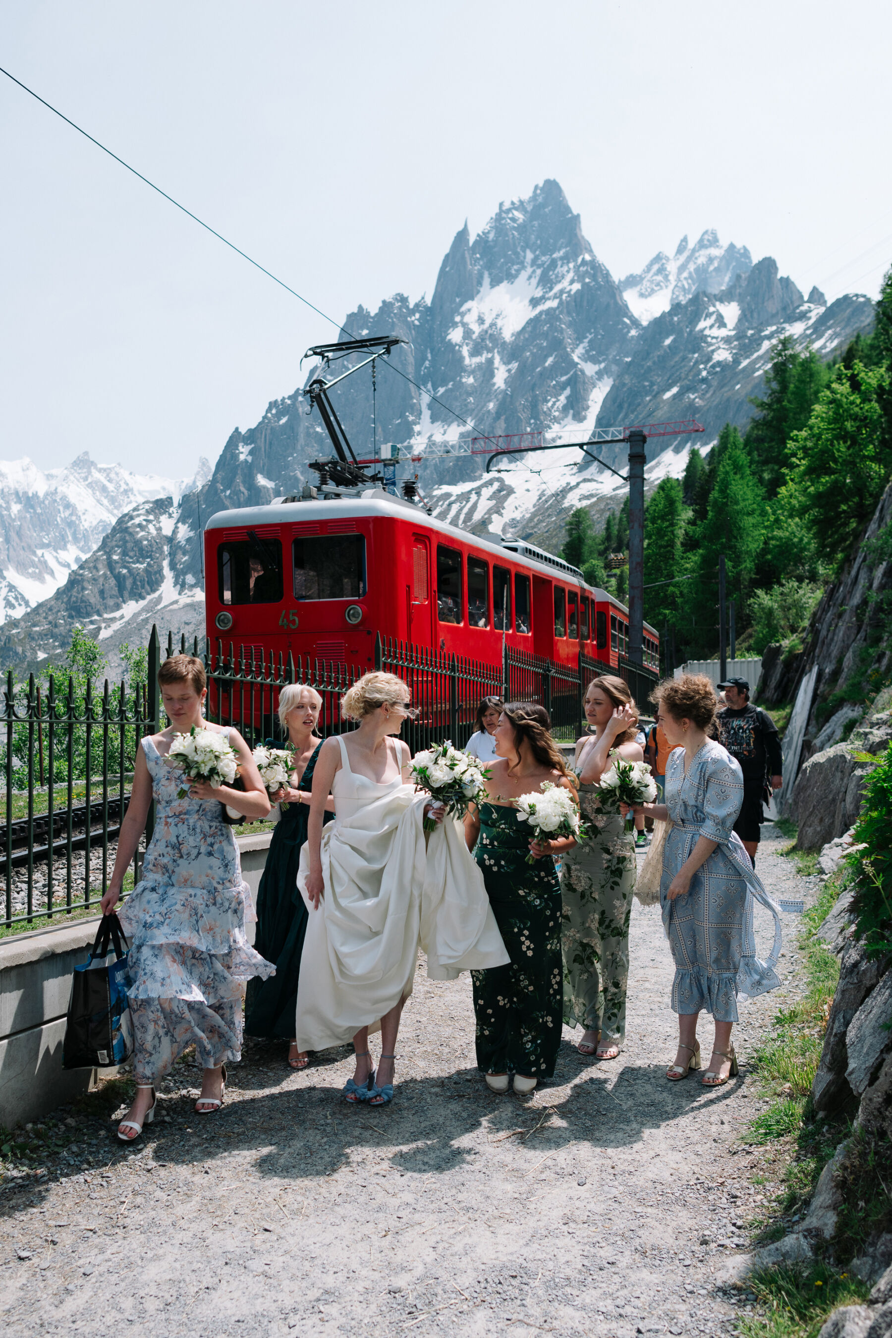 Georgia in Emilia Wickstead, For Her Classy & Elegant Black Tie Mountain Wedding in the Chamonix 19 Bride and her bridesmaids walking through the foothills of Mont Blanc at Chamonix. Emilia Wickstead wedding dress and brides maids in mismatched pale blue dresses.