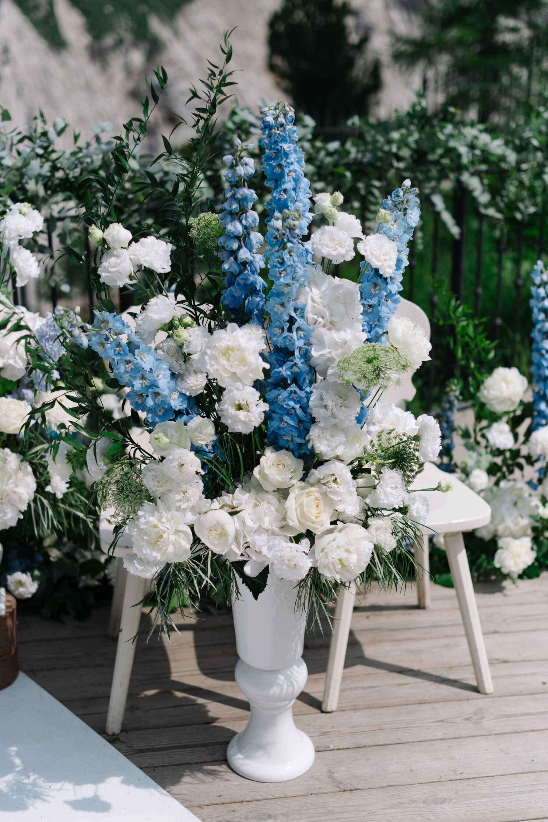 Georgia in Emilia Wickstead, For Her Classy & Elegant Black Tie Mountain Wedding in the Chamonix 23 Blue and white wedding flowers located next to chairs for a wedding ceremony.