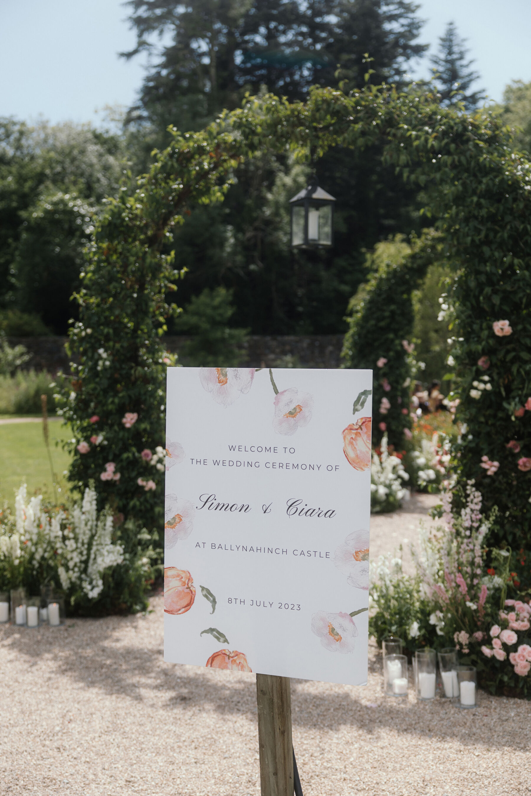 Romantic Ballynahinch Castle Wedding: Ciara in Danielle Frankel 20 Wedding welcome sign in the grounds at Ballynahinch Castle in Ireland. It is decorated gently with peaches and flowers.