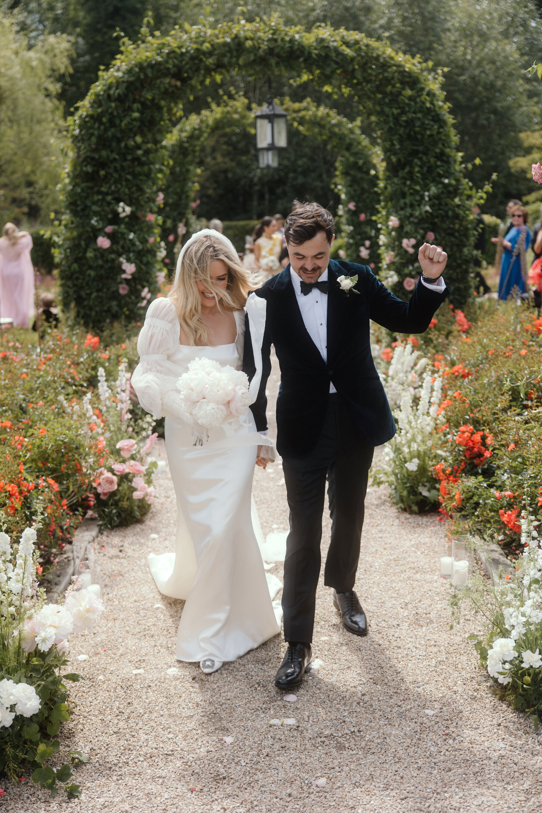 Romantic Ballynahinch Castle Wedding: Ciara in Danielle Frankel 23 Danielle Frankel bride and groom in black tie. The couple are walking back down their wedding ceremony aisle smiling and happy.