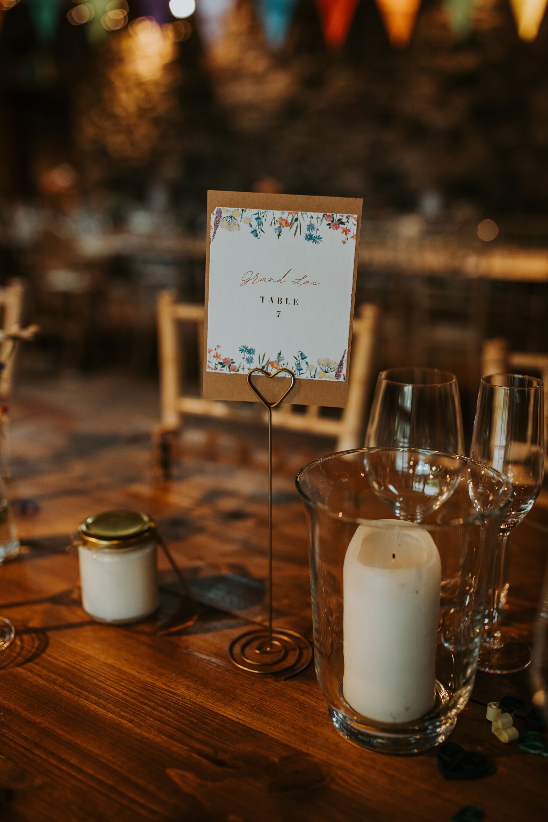 Sophie & Hal's Joyful, Colourful & Sustainable DIY Barn Wedding at Low Hall The Lakes 49 DIY wedding stationery created by the bride using CANVA. Simple table numbers framed with wildflowers.