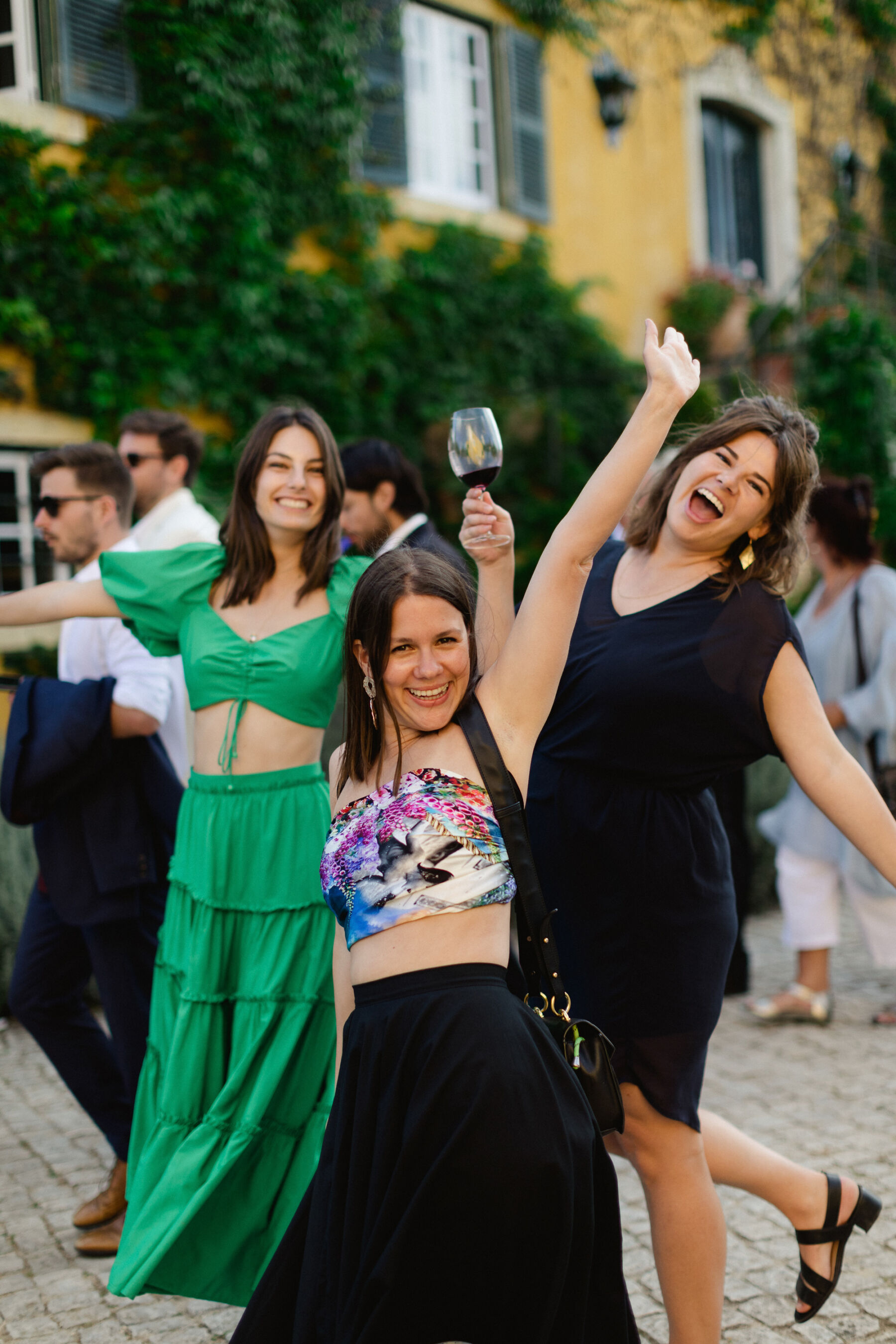 Olivia & Tim's Classy & Elegant Vineyard Wedding in Portugal 34 Wedding guests having fun and holding their glasses in the air.