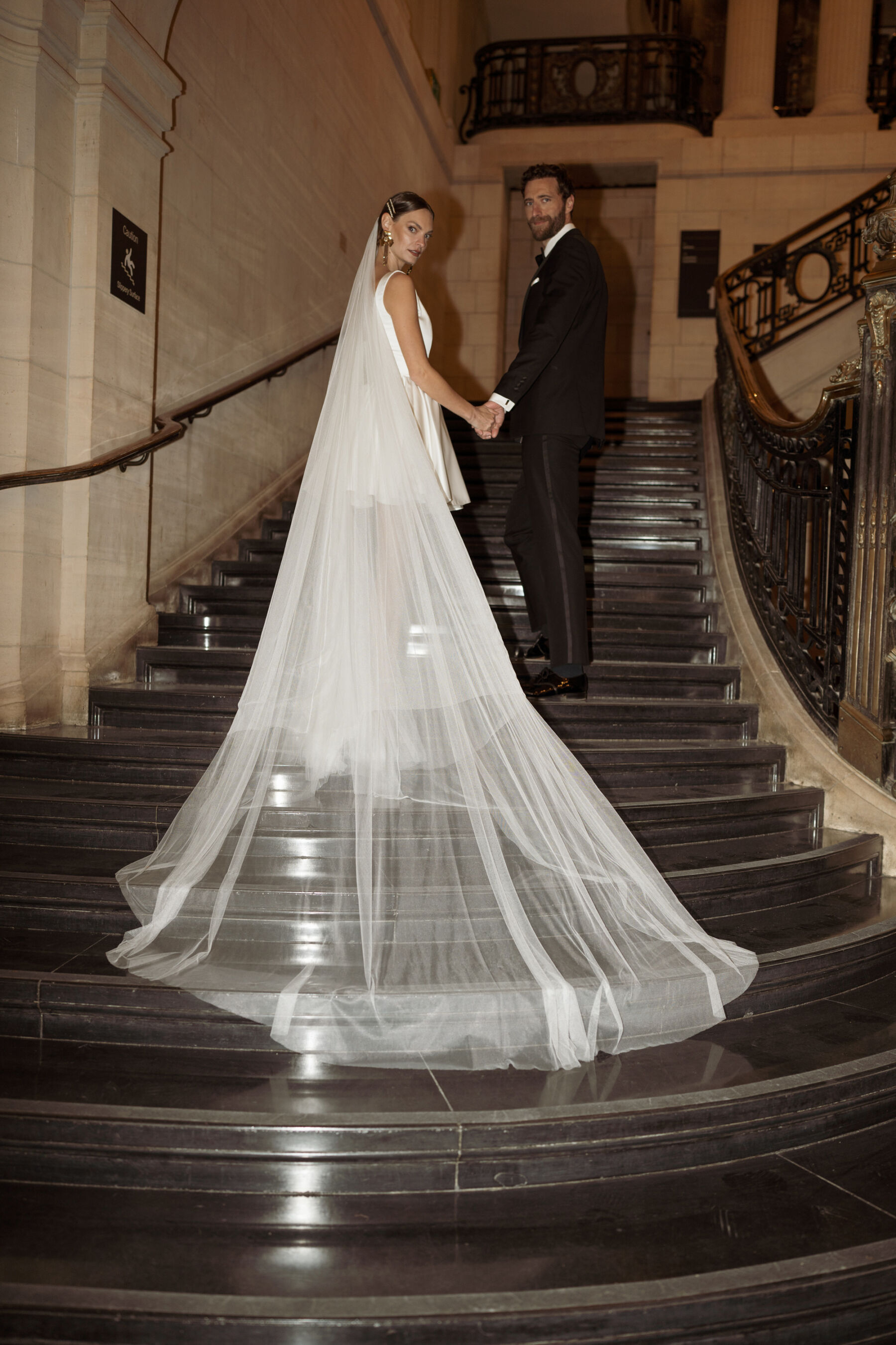 Bride wearing a long veil standin on the iconic staircase at 10-11 Carlton Terrace.
