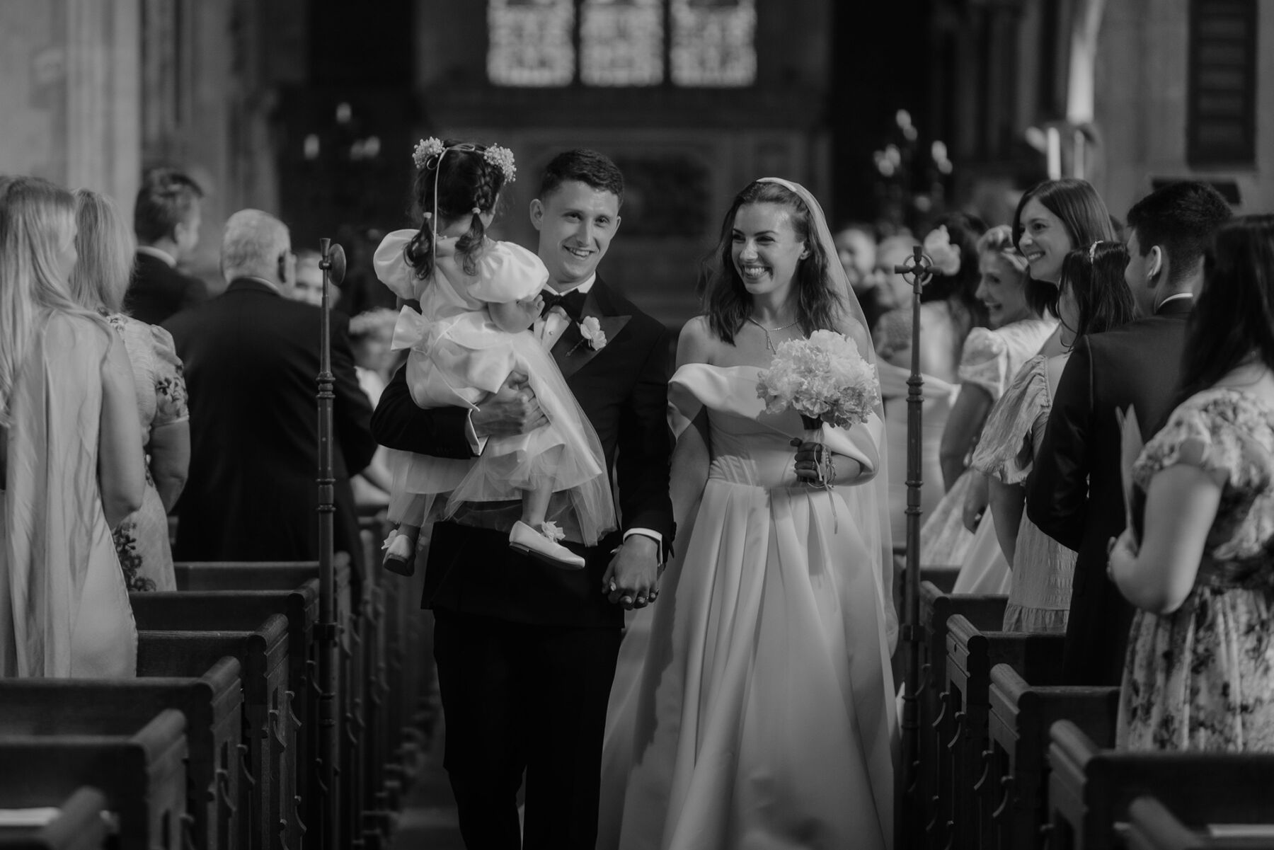 An Investment Banker & Her Prestwold Hall Wedding, with a Milla Nova Gown & Berta Legging Boots 22 Groom holding the flower girl as he accompanies his new bride back down the aisle.