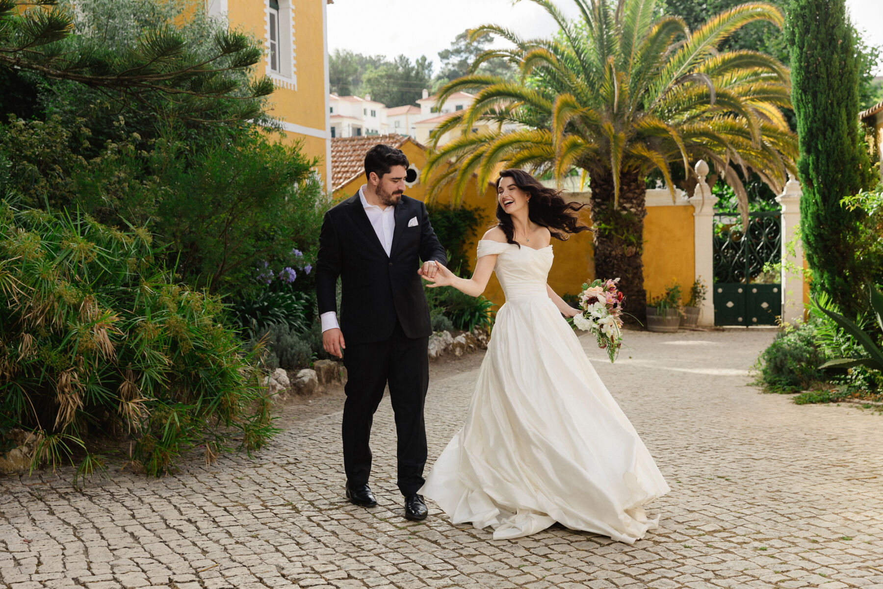 Olivia & Tim's Classy & Elegant Vineyard Wedding in Portugal 30 Happy and joyful bride and groom wandering the streets in Portugal after their wedding ceremony.