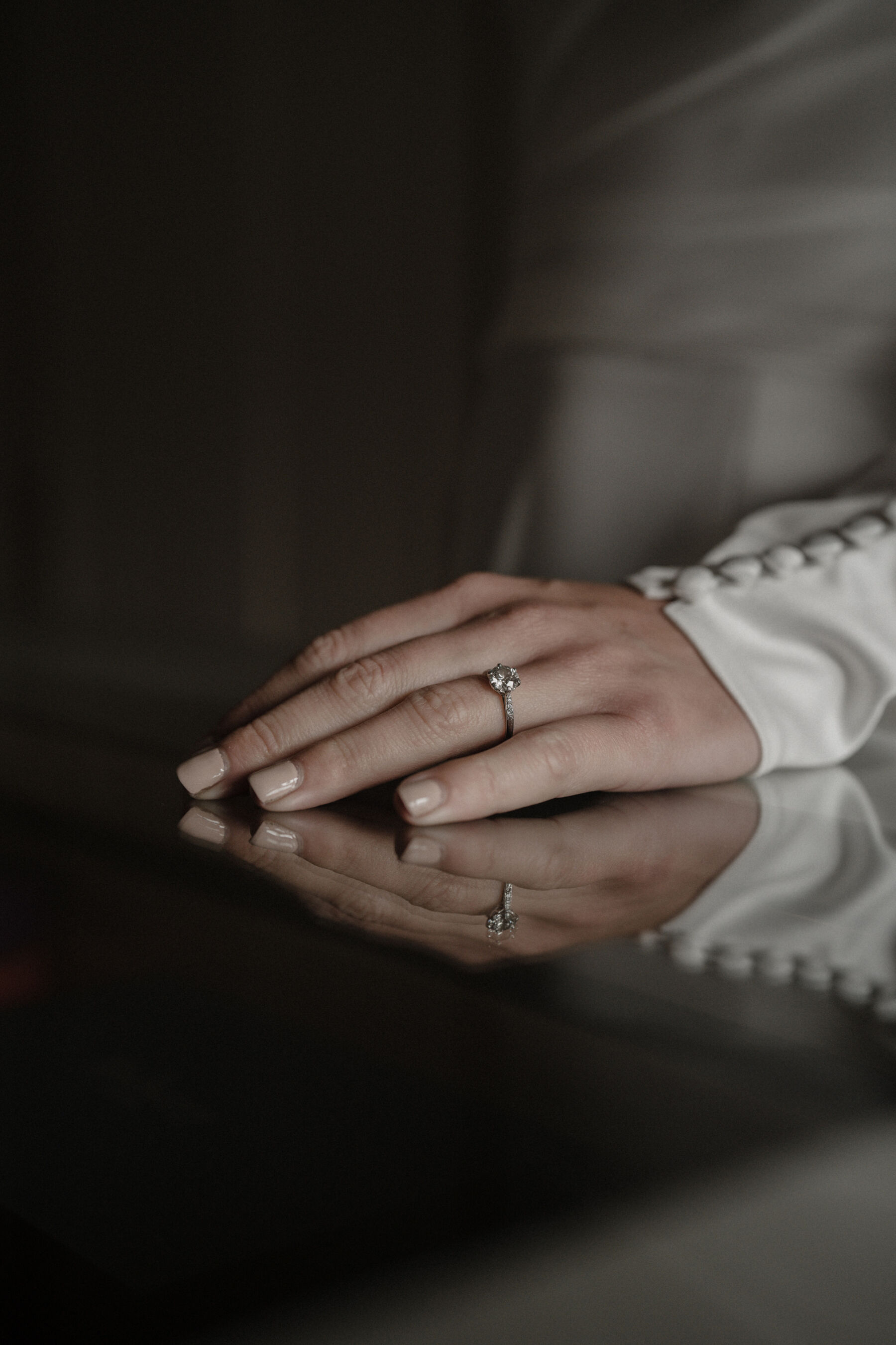 Bridal nails with nude nail varnish and cuffs with buttons running up the sleeve.