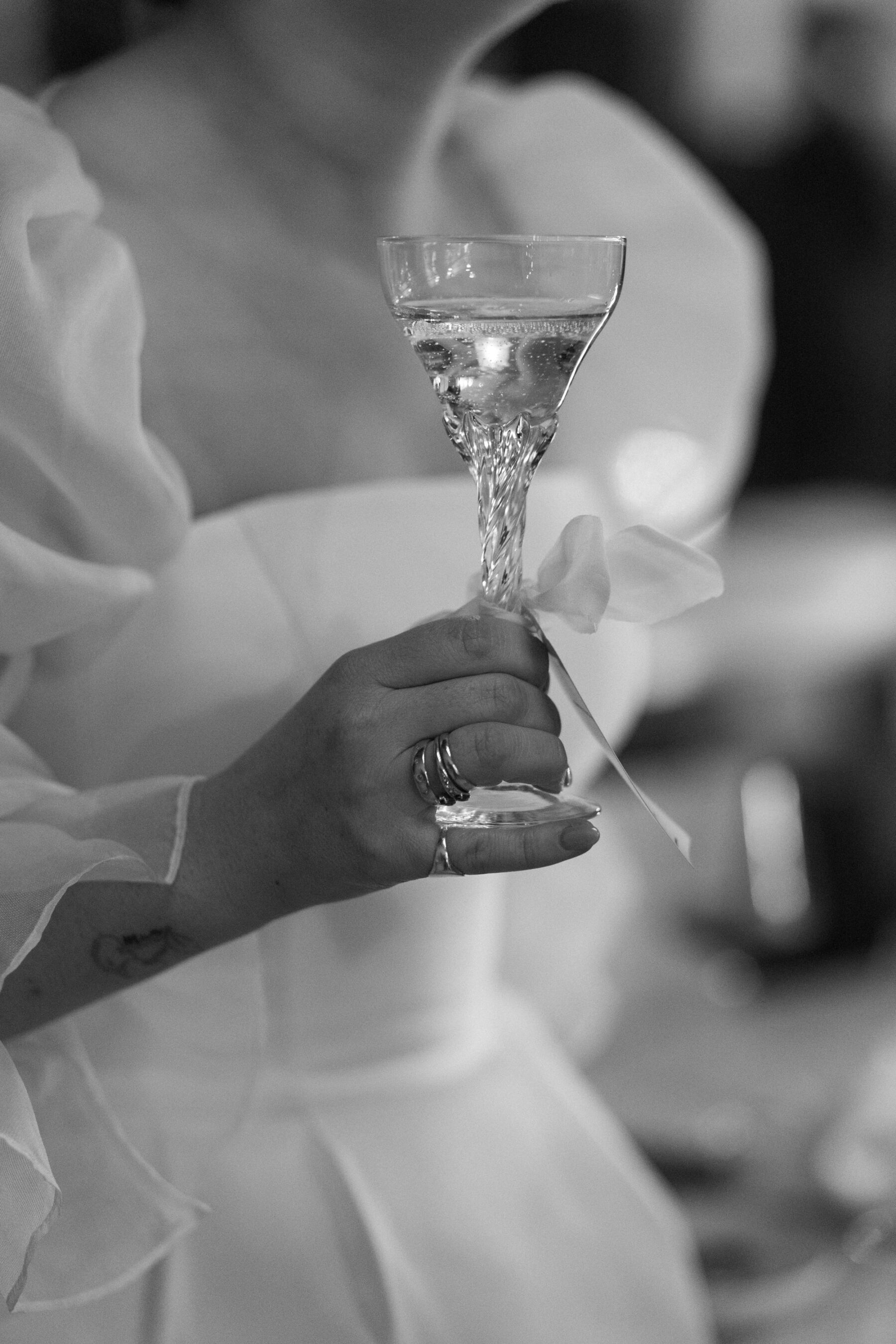 Maddy & Nik’s Cosy and Intimate Winter Wedding with a Custom Jesus Peiro Gown 32 Close up detail shot of bride holding a crystal cut wedding glass.
