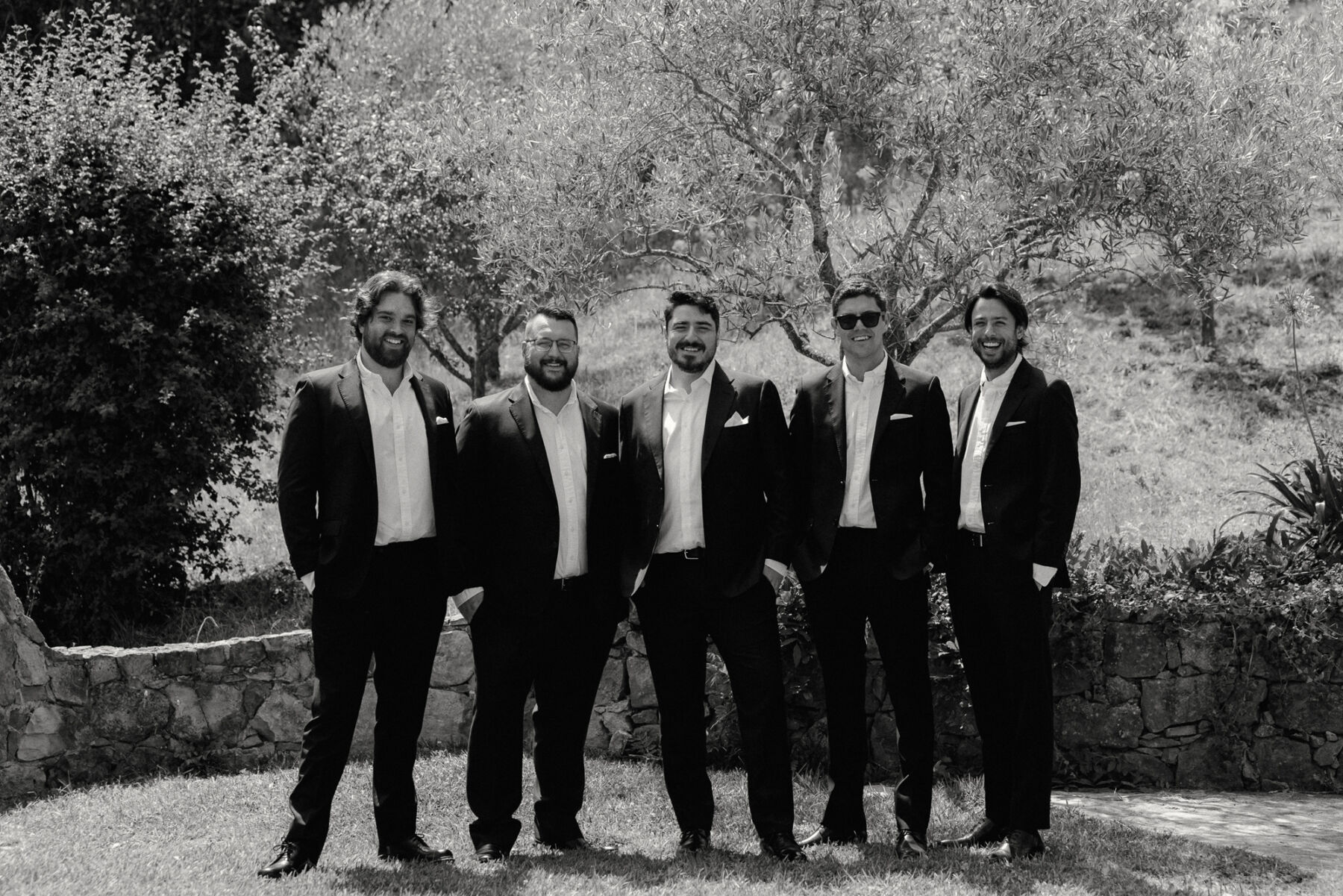 Olivia & Tim's Classy & Elegant Vineyard Wedding in Portugal 15 Groom and groomsmen in dark suits with no tie and open collars.