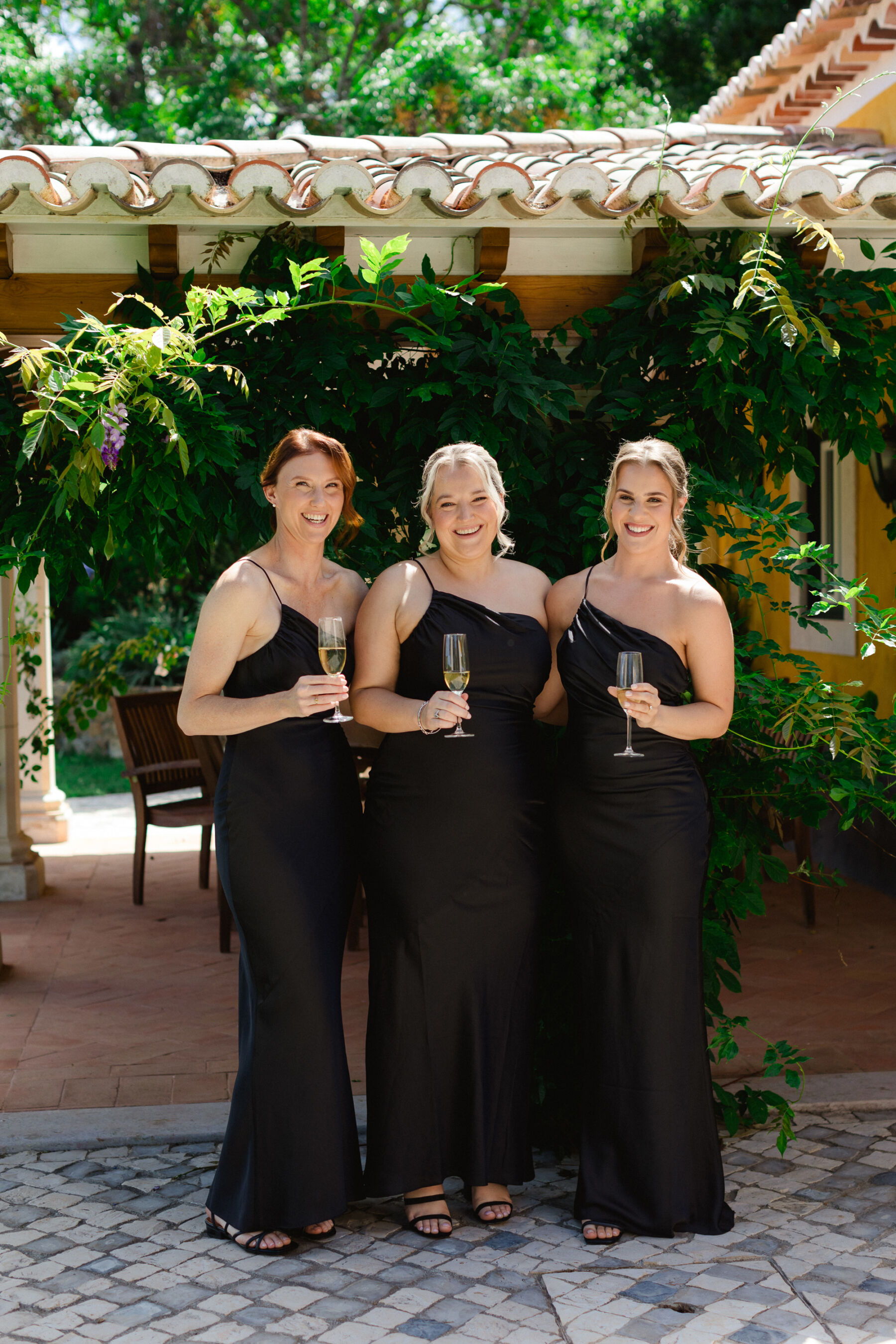Olivia & Tim's Classy & Elegant Vineyard Wedding in Portugal 13 Bridesmaids in black strappy asymmetrical dresses.