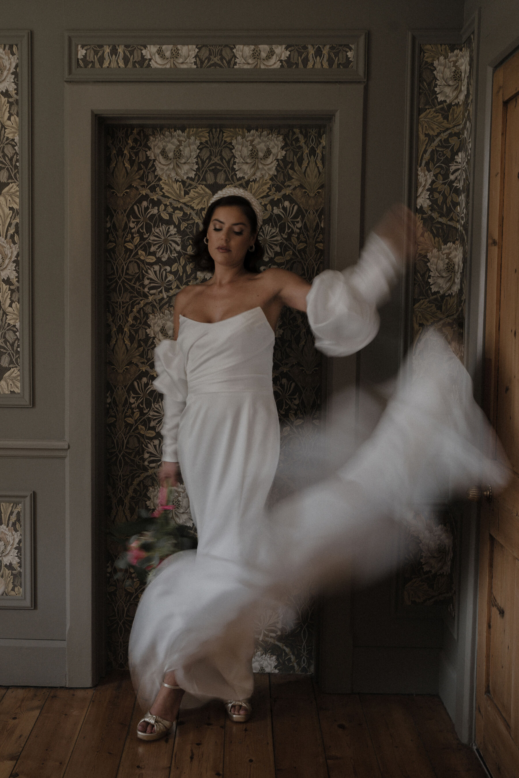 Movement shot of a bride wearing a Watters wedding dress and pearl headband.