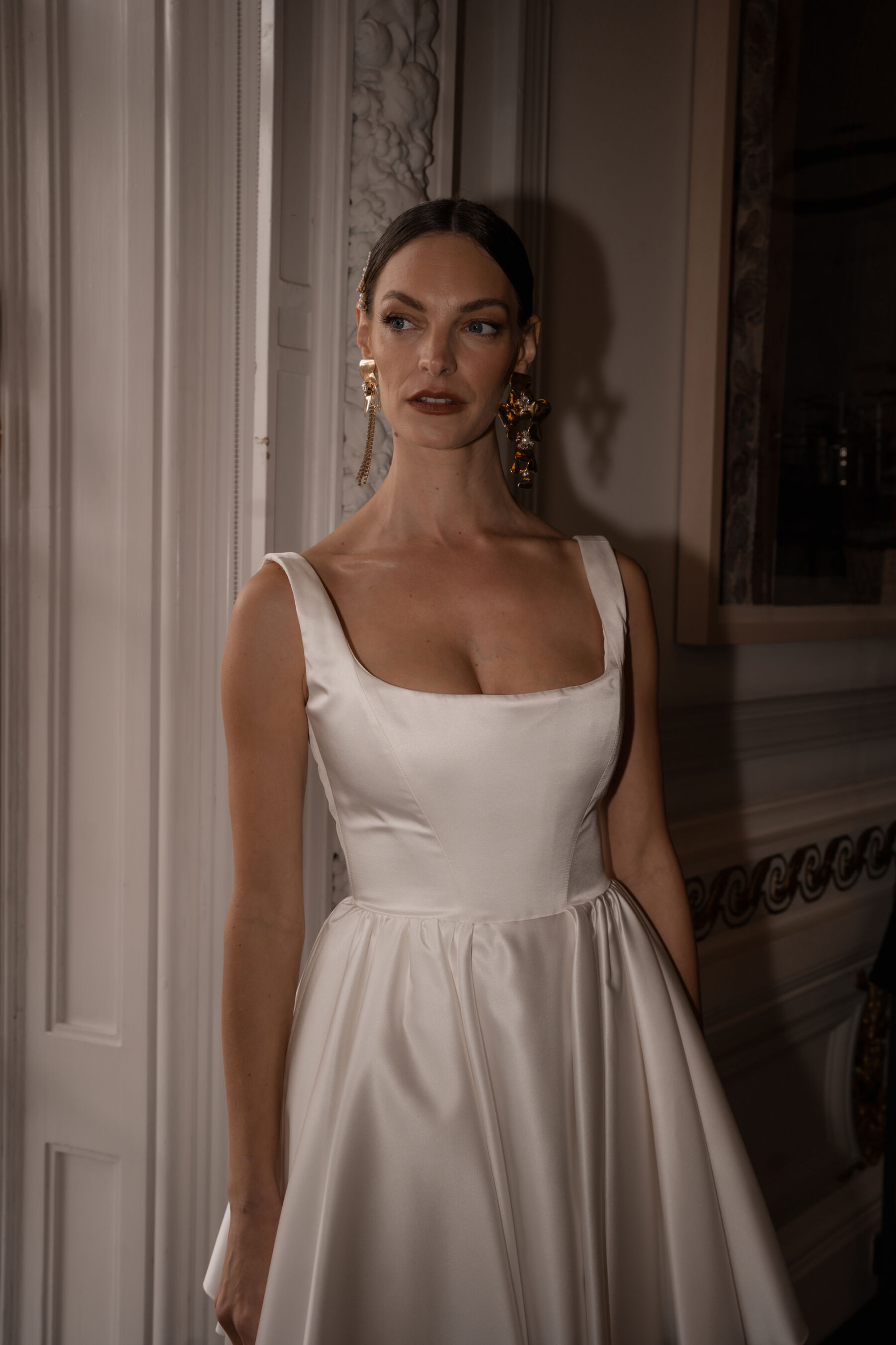 Bride wearing large gold statement earrings and a cute and playful, short wedding dress by Halfpenny London.