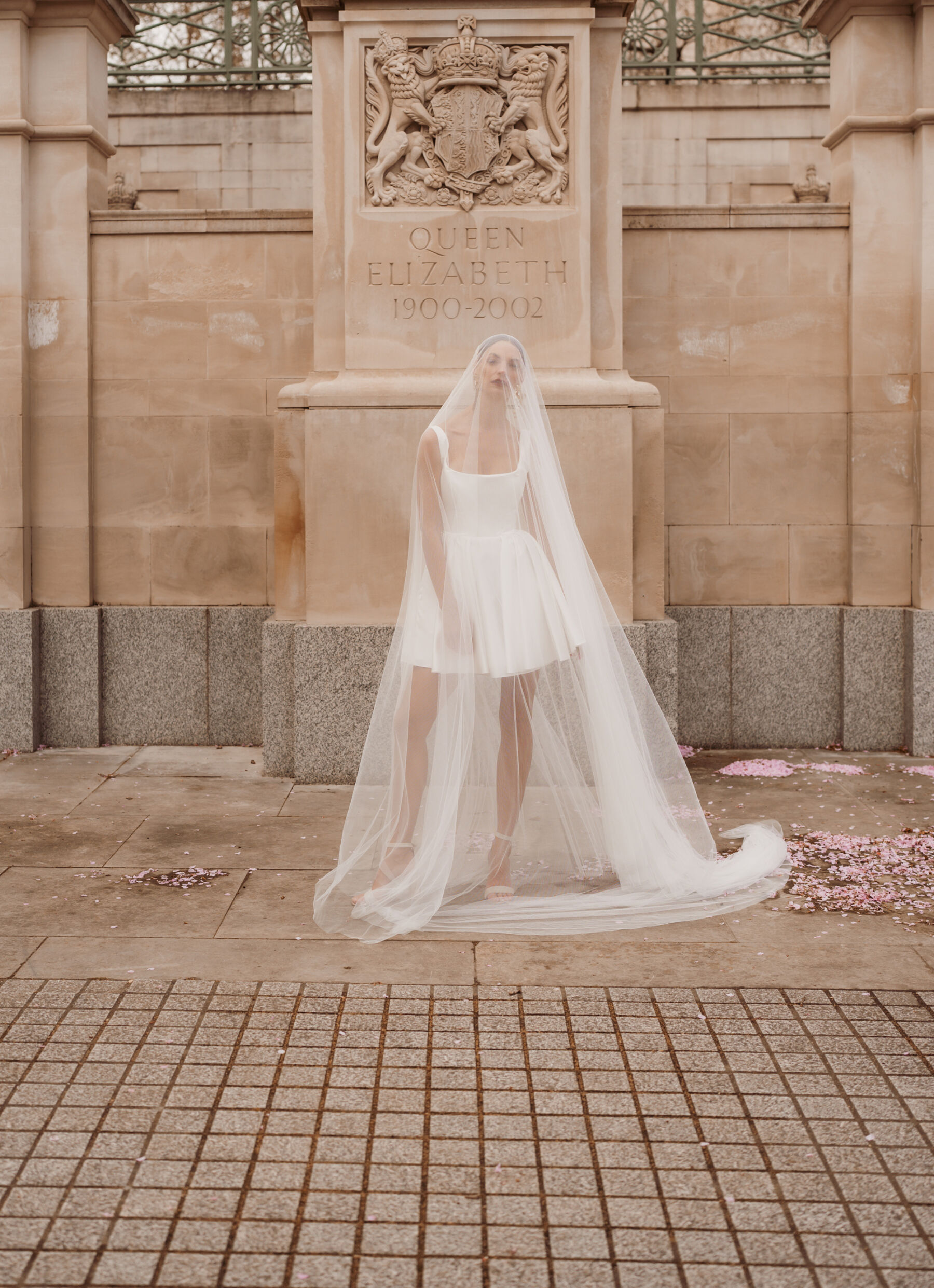 Bride wearing a short wedding dress by Halfpenny London with a long veil covering her whole outfit.