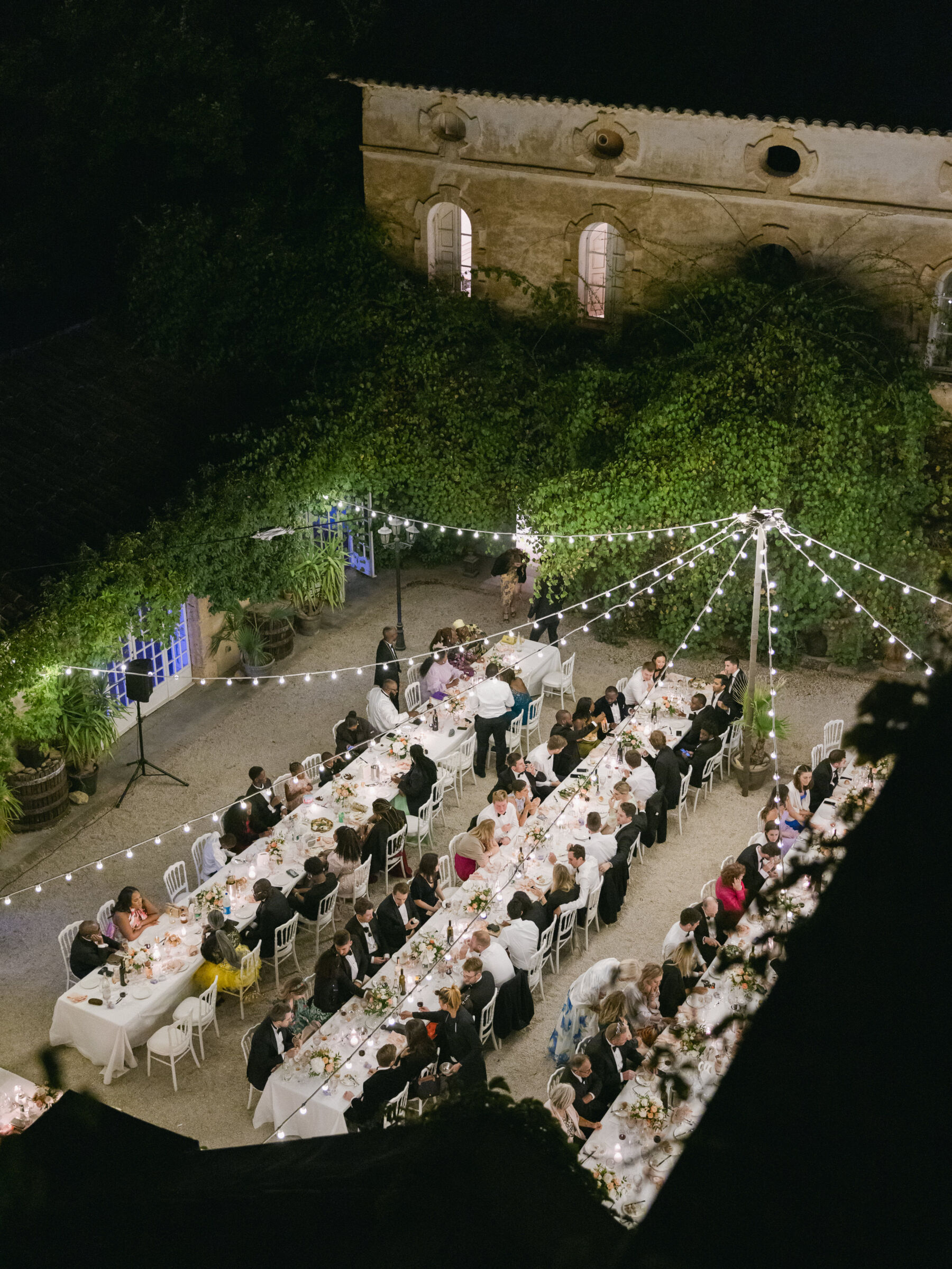 French Riviera Chic Wedding at Château Robernier, Provence, with Lawyer Chanel in Sassi Holford 37 Festoon lights hanging over hte courtyard at night for a wedding at Chateau Robernier in Cotignac, Provence, France. Sébastien Boudot Photography.