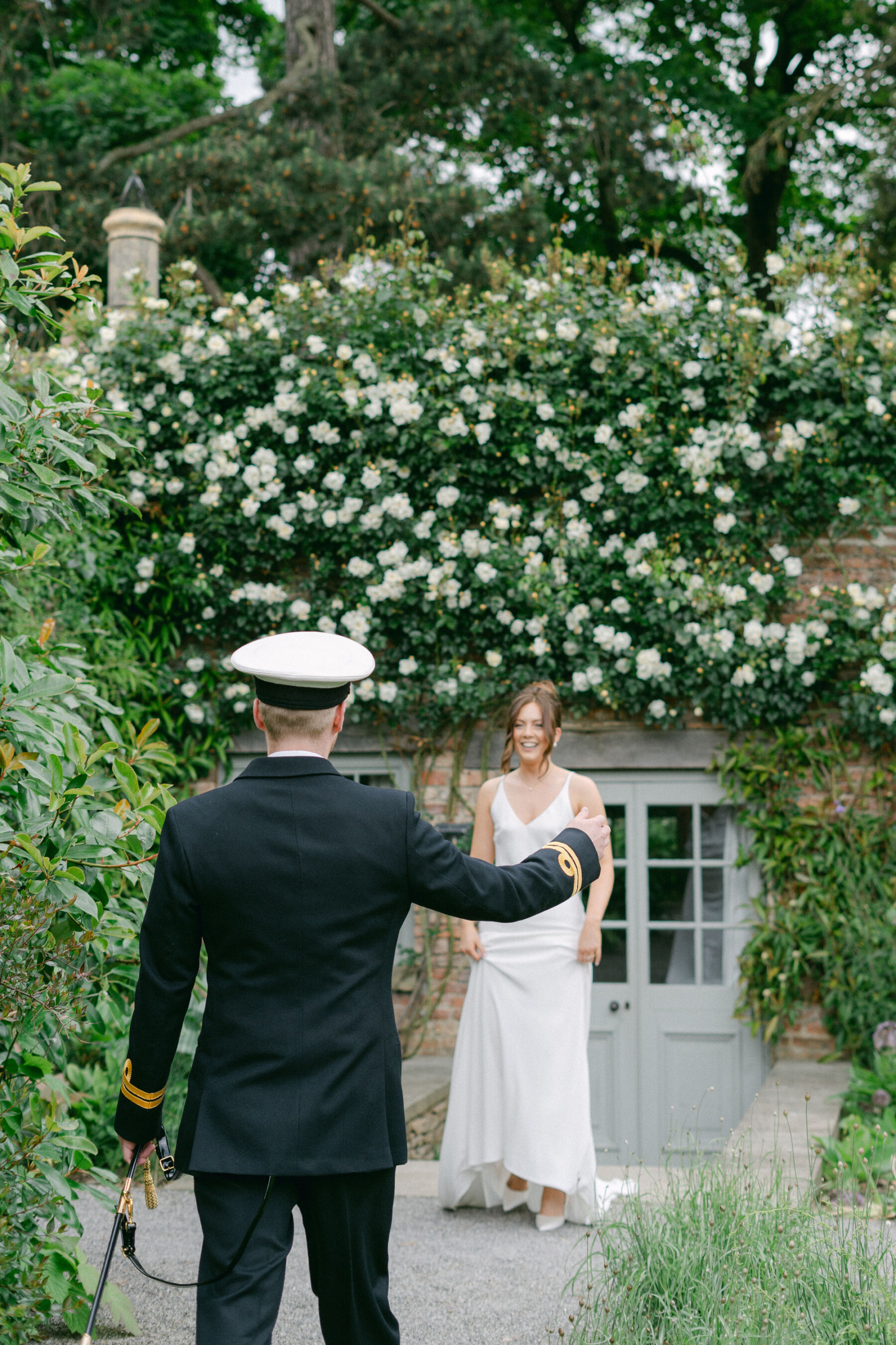 Navy officer in military uniform seeing his bride during a first look on their wedding day.