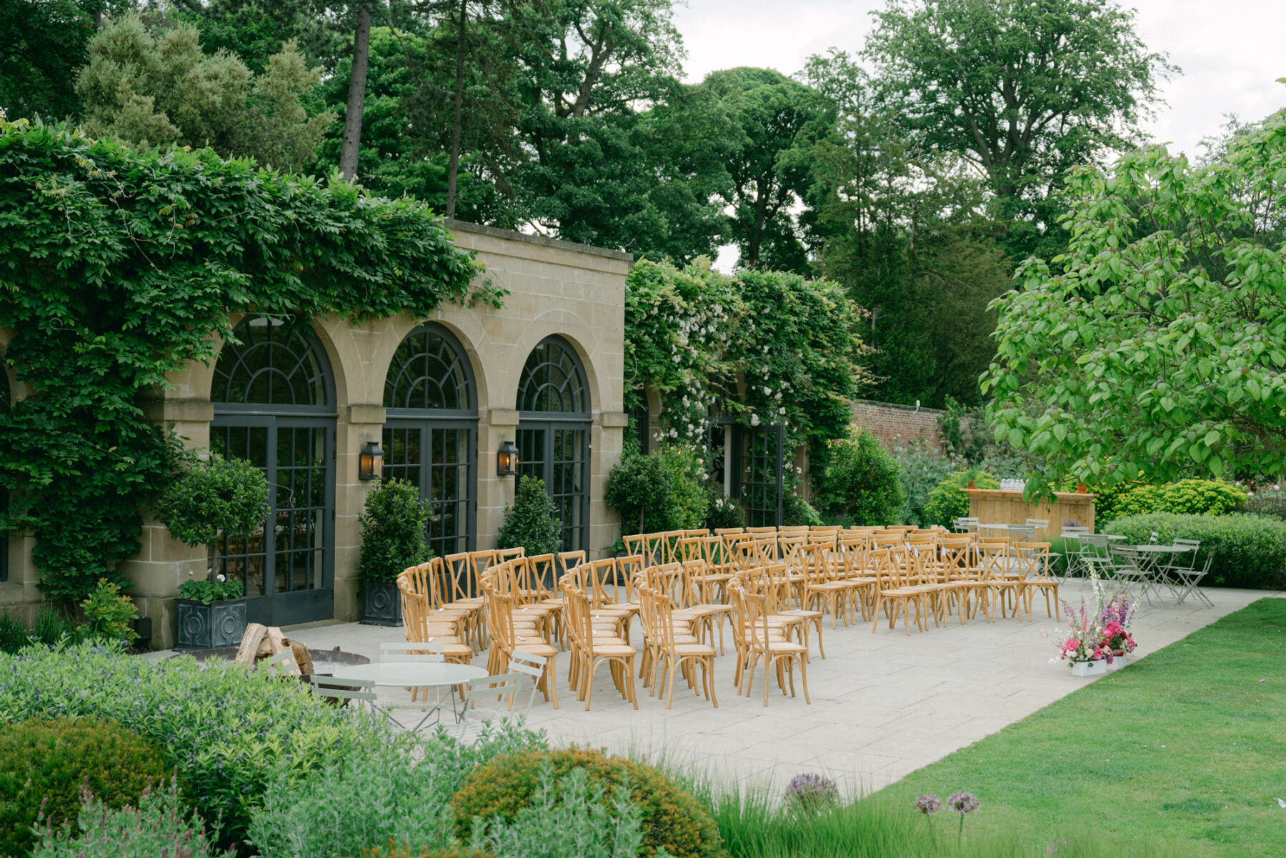Wedding ceremony seating arranged in a curve for a wedding outside the Fig House at Middleton Lodge.