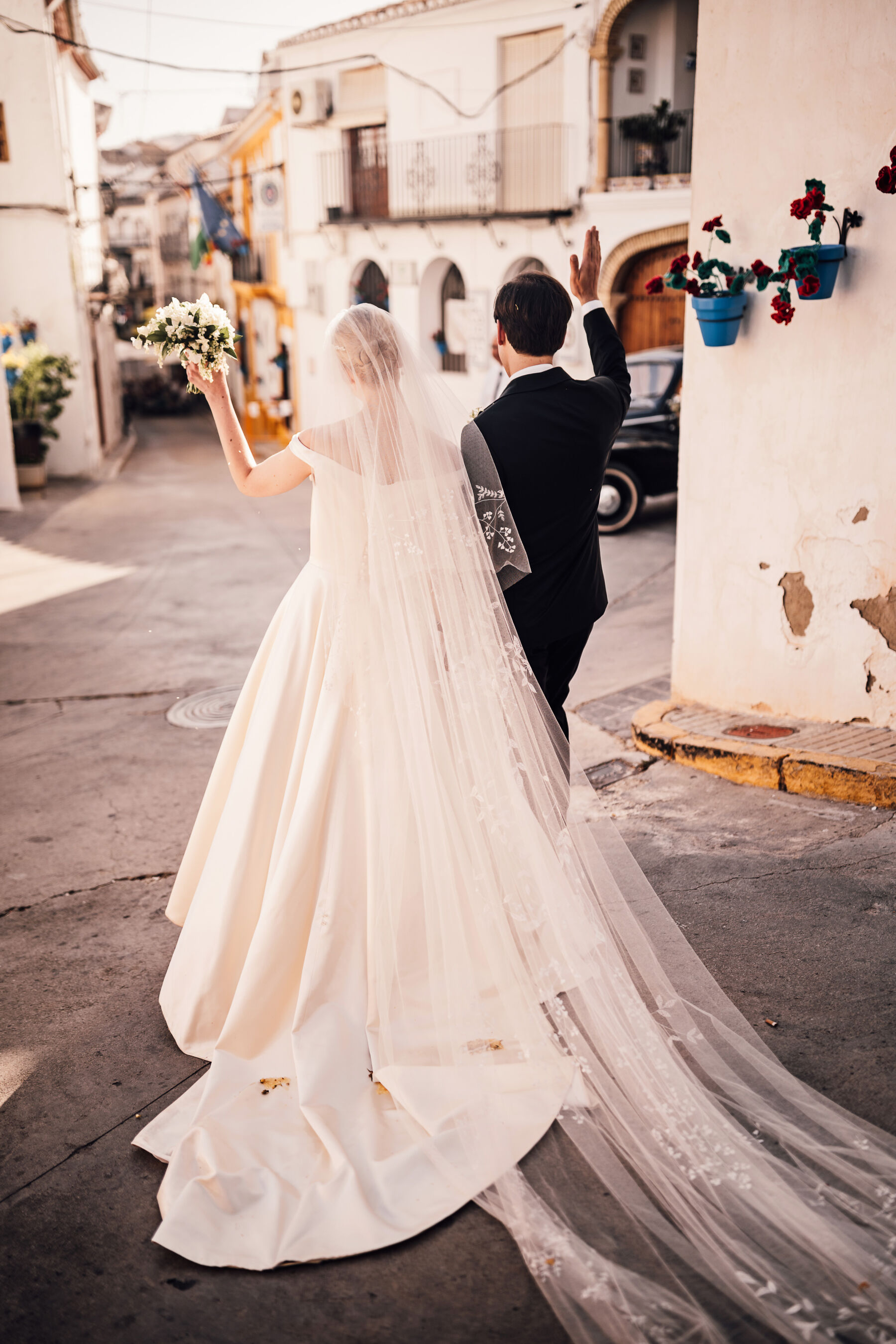 Alexandra Wore Phillipa Lepley For Her Romantic Destination Wedding in Spain 29 Bride and groom walking through the streets of Spain on their wedding day. She wears Phillipa Lepley - the groom is in black tie tuxedo.