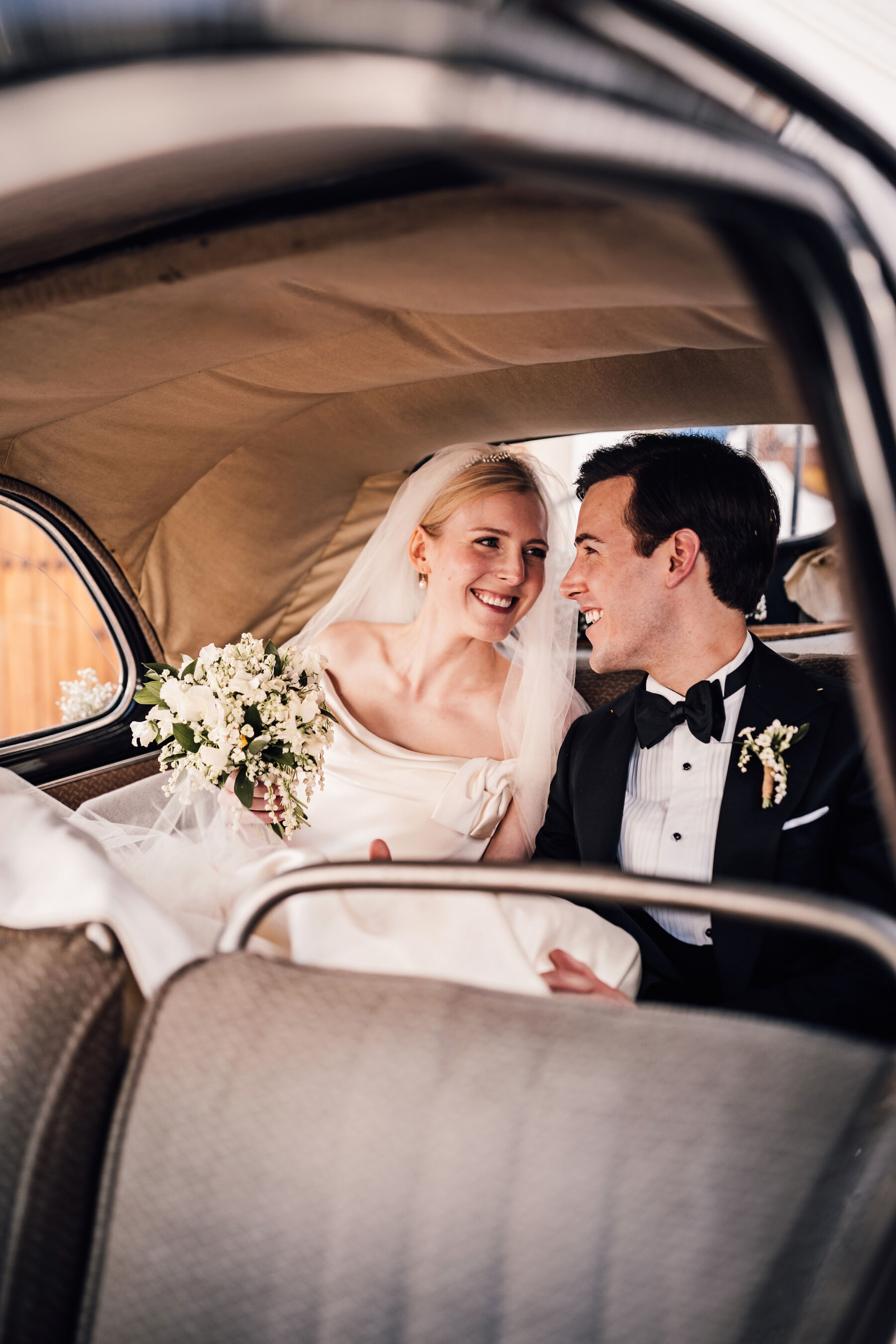 Alexandra Wore Phillipa Lepley For Her Romantic Destination Wedding in Spain 30 Bride and groom cosying up to one another whilst seated in the wedding car. She wears Phillipa Lepley - the groom is in black tie tuxedo.