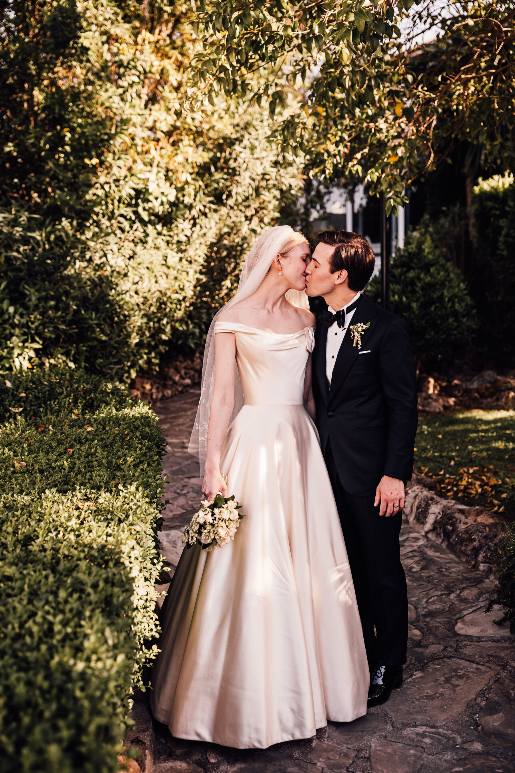 Alexandra Wore Phillipa Lepley For Her Romantic Destination Wedding in Spain 28 Bride and groom kissing outdoors on their Spanish wedding day. She wears Phillipa Lepley - the groom is in black tie tuxedo.