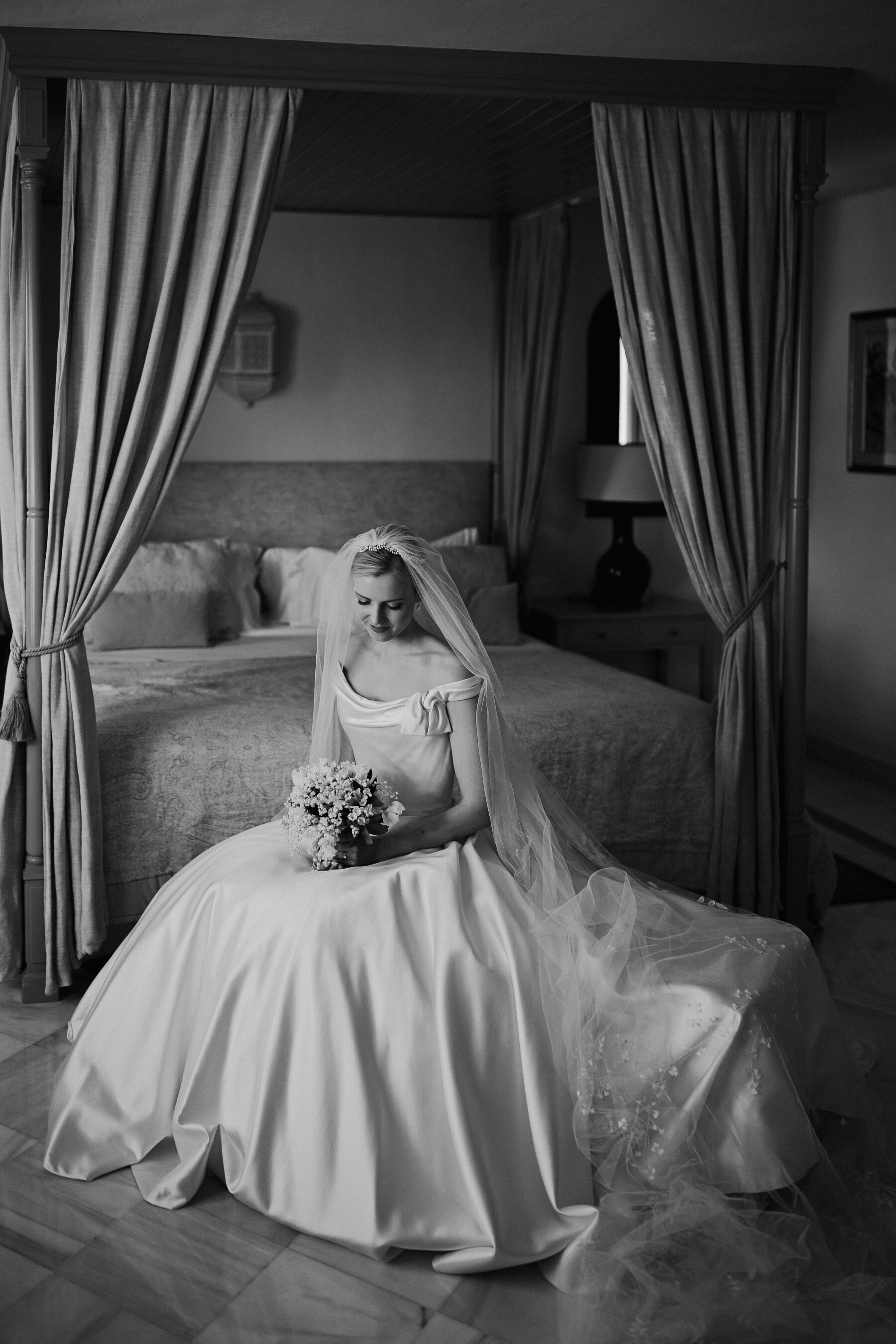 Alexandra Wore Phillipa Lepley For Her Romantic Destination Wedding in Spain 17 Bride sat on the bed looking down at her bouquet, she wears a couture Phillipa Lepley bridal gown and wedding veil.