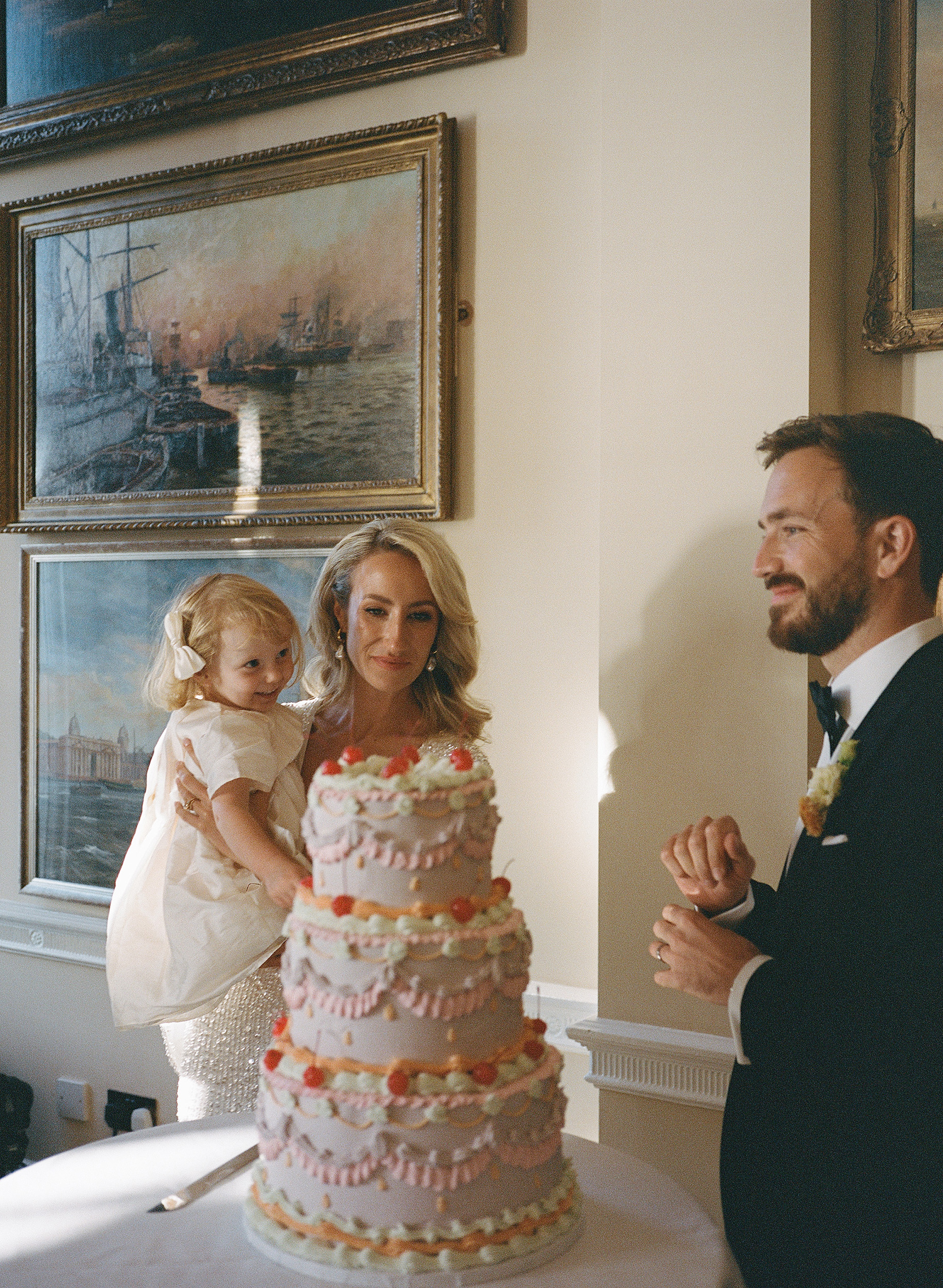 Camilla Wore Eva Lendel for Her Colourful Wedding Inspired by Artist Luke Howard Hall 31 3 tier wedding cake with frilly icing and cherries.
