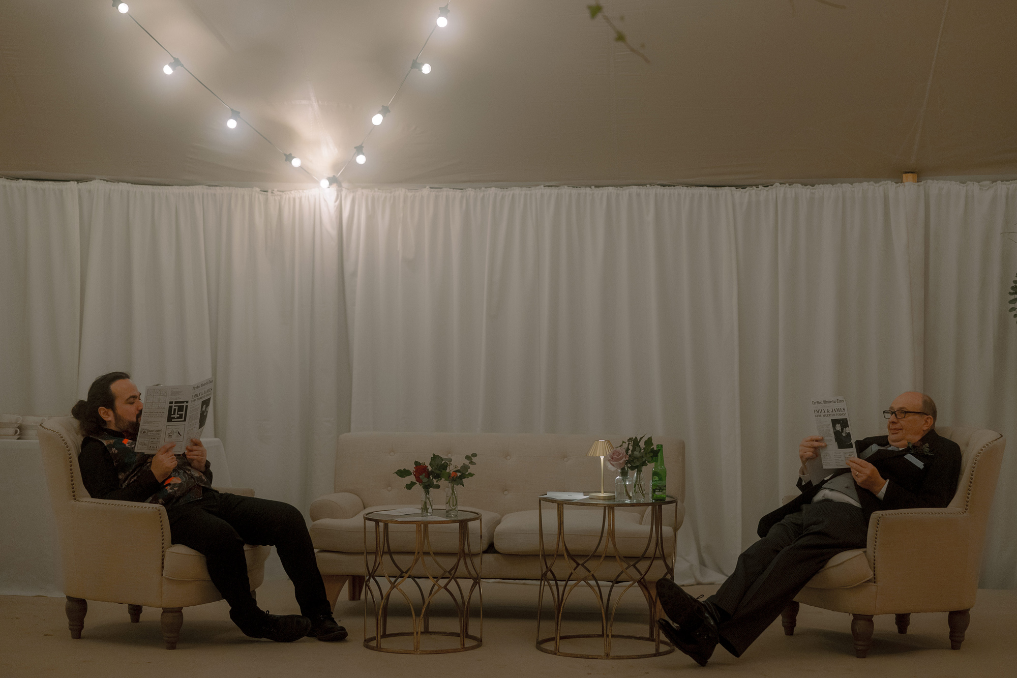 A Movie & Literary Inspired Romantic Christmas Wedding 61 Wedding guests reclining into comfy chairs inside a wedding marquee.