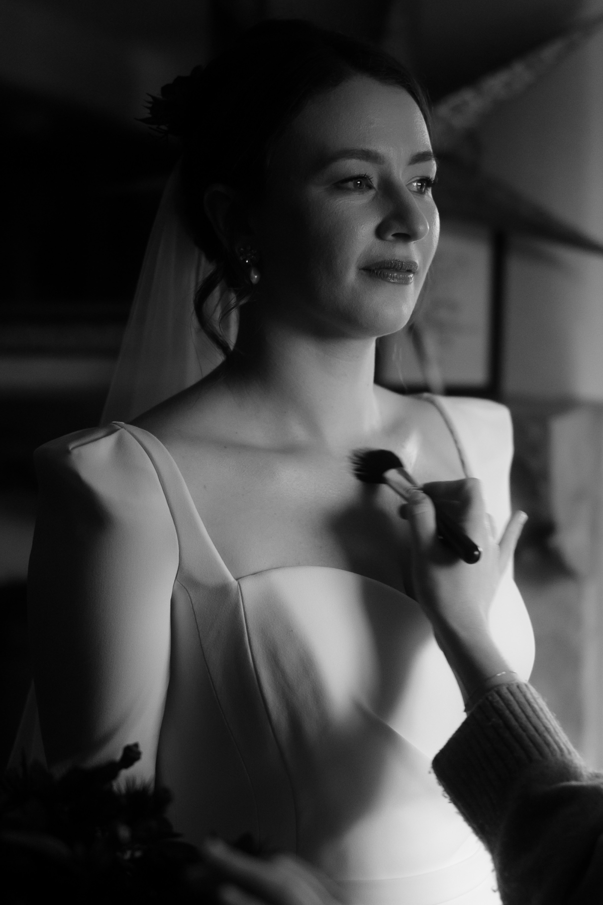 A Movie & Literary Inspired Romantic Christmas Wedding 19 Black and white images of an elegant bride in a Suzanne Neville wedding dress having her makeup done.