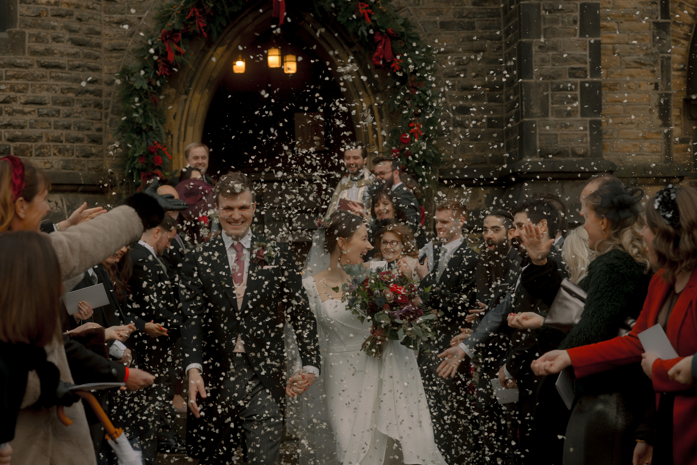 A Movie & Literary Inspired Romantic Christmas Wedding 52 Bride and groom exiting the church on their christmas wedding being showered in confetti.