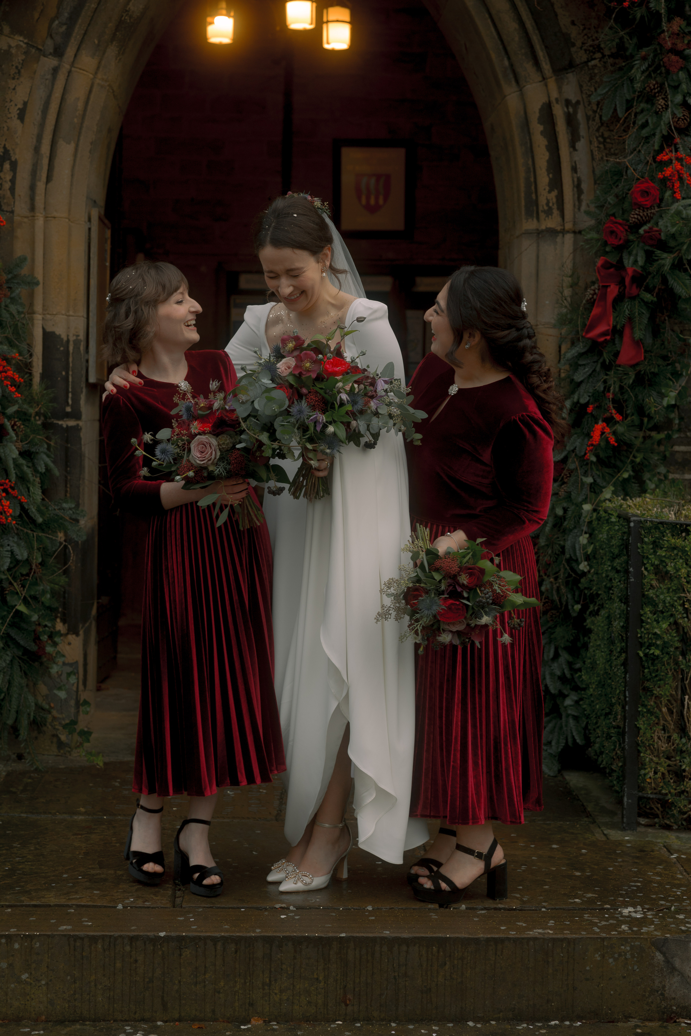 A Movie & Literary Inspired Romantic Christmas Wedding 53 Bridesmaids in red velvet dresses from Hobbs for a Christmas wedding.