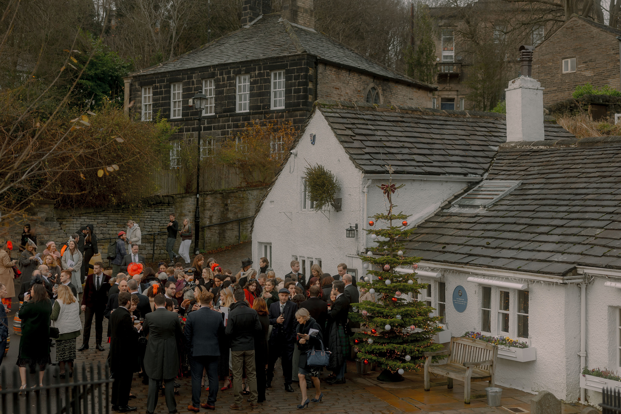 A Movie & Literary Inspired Romantic Christmas Wedding 55 Christmas wedding day scene with guests walking on the streets past decorated Christmas trees.