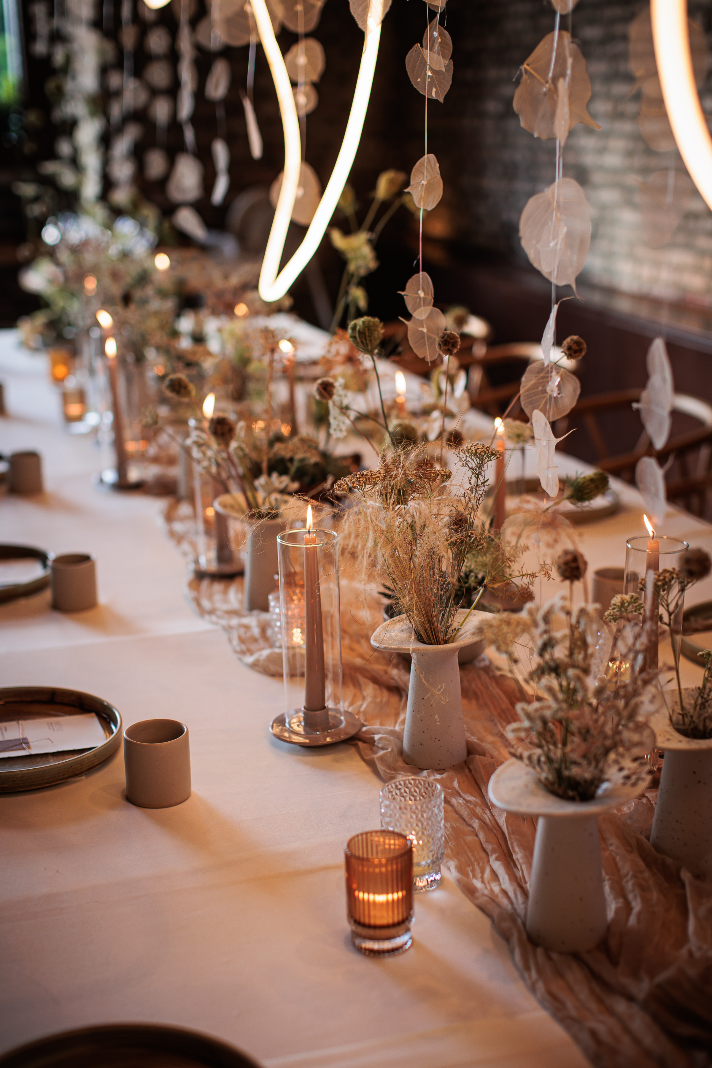Danielle Frankel Intimate Italian Wedding 96 1 - Kathryn in Danielle Frankel for her Intimate Italian Wedding Contemporary wedding reception setting with candles in hurricane glass jars, modern stoneware vases and dried flowers and seed heads.