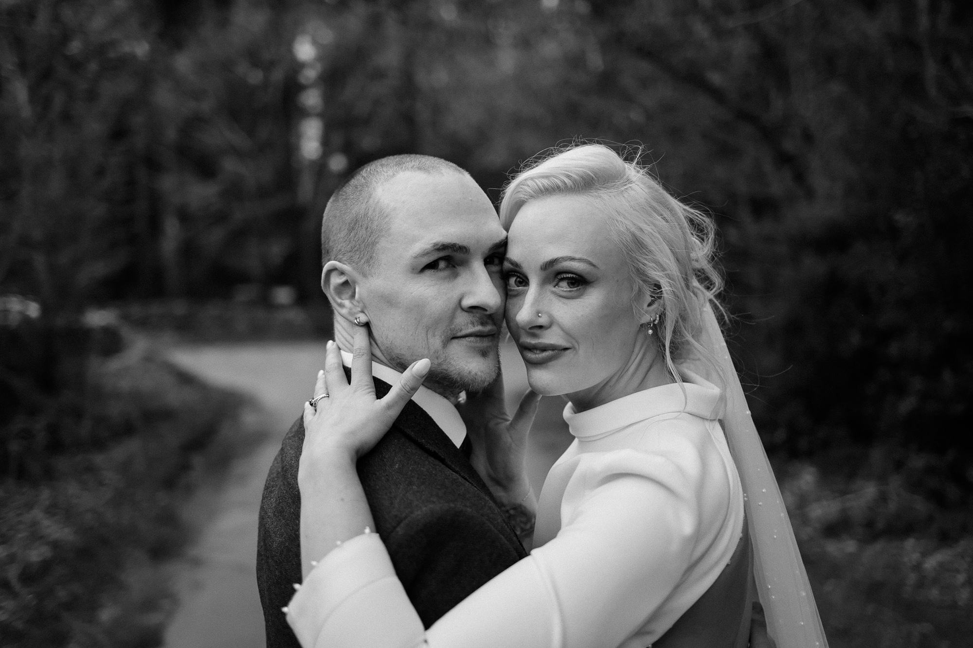 Bon Bride Elegance for a Stylish Healey Barn Wedding in Northumberland 41 Intimate shot of bride in a long sleeved, backless Bon Bride wedding dress hugging her groom closely and looking at the camera.