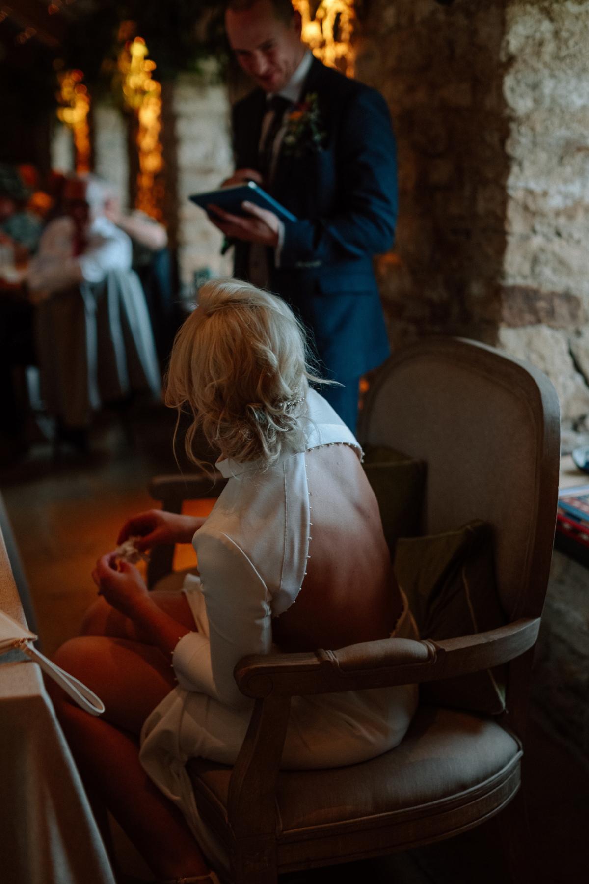 Bon Bride Elegance for a Stylish Healey Barn Wedding in Northumberland 38 Back of a bride whose face is turning towards her groom as he delivers a speach. She wear a backless wedding dress by Bon Bride.