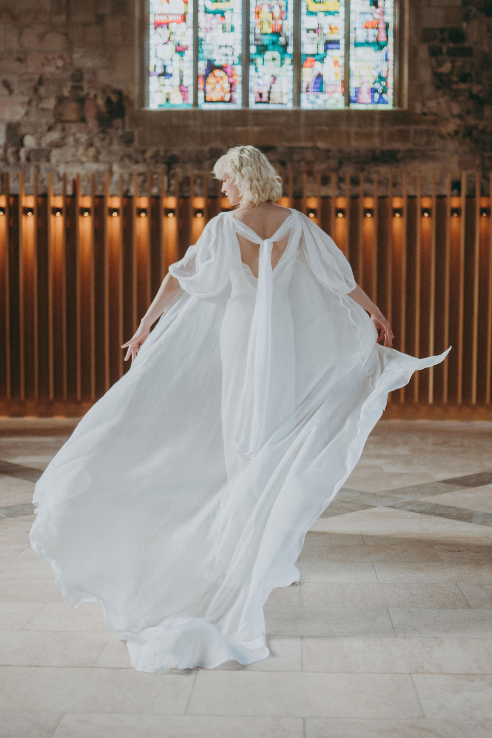 Bride is wafting an ethereal wedding dress by Rolling in Roses. Ethical and sustainable British bridal fashion.