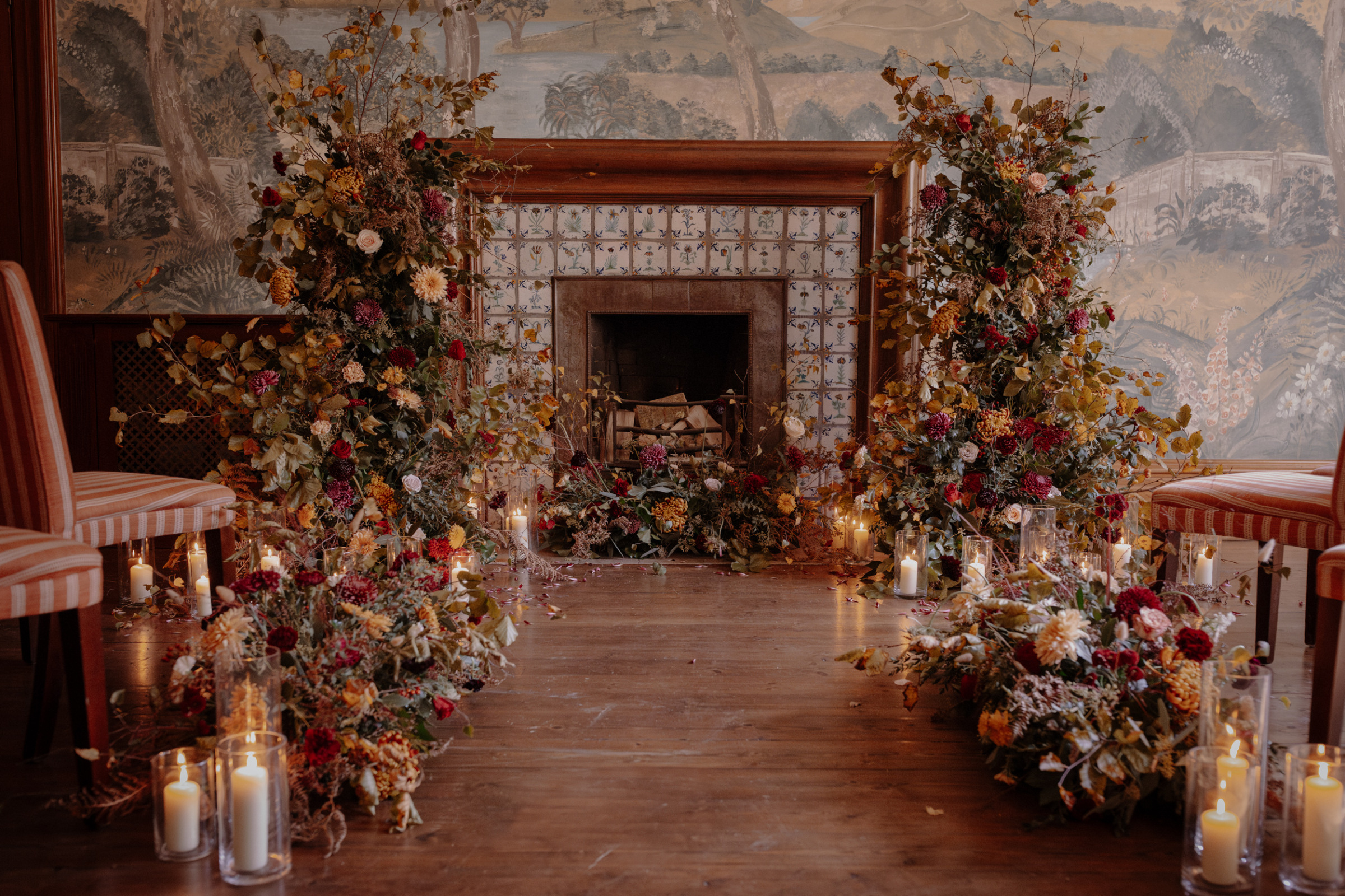 A Little Wild, A Little Luxe: Helen Rose Photography's Beautiful Peak District Editorial 28 wedding reception space by a fire place surrounded by an abundance of Autumn wedding flowers and candles in hurricance jars.